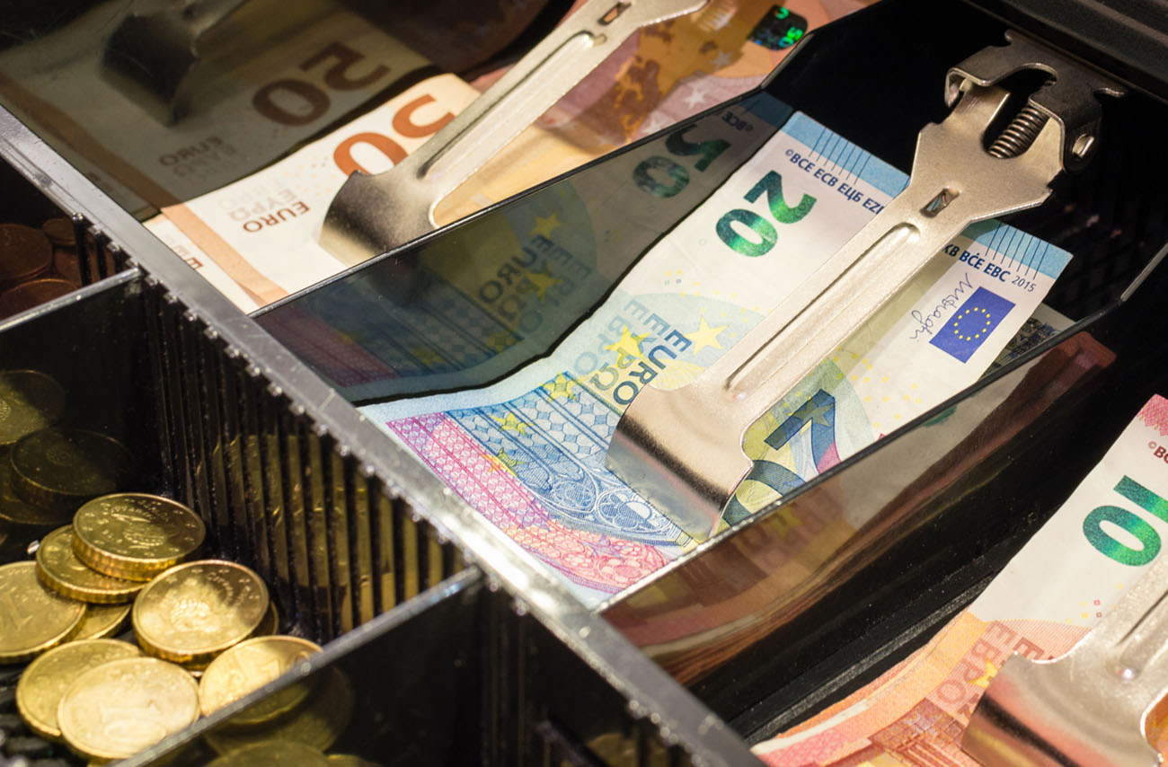 High angle view of cash register drawer full of coins and euro bills
