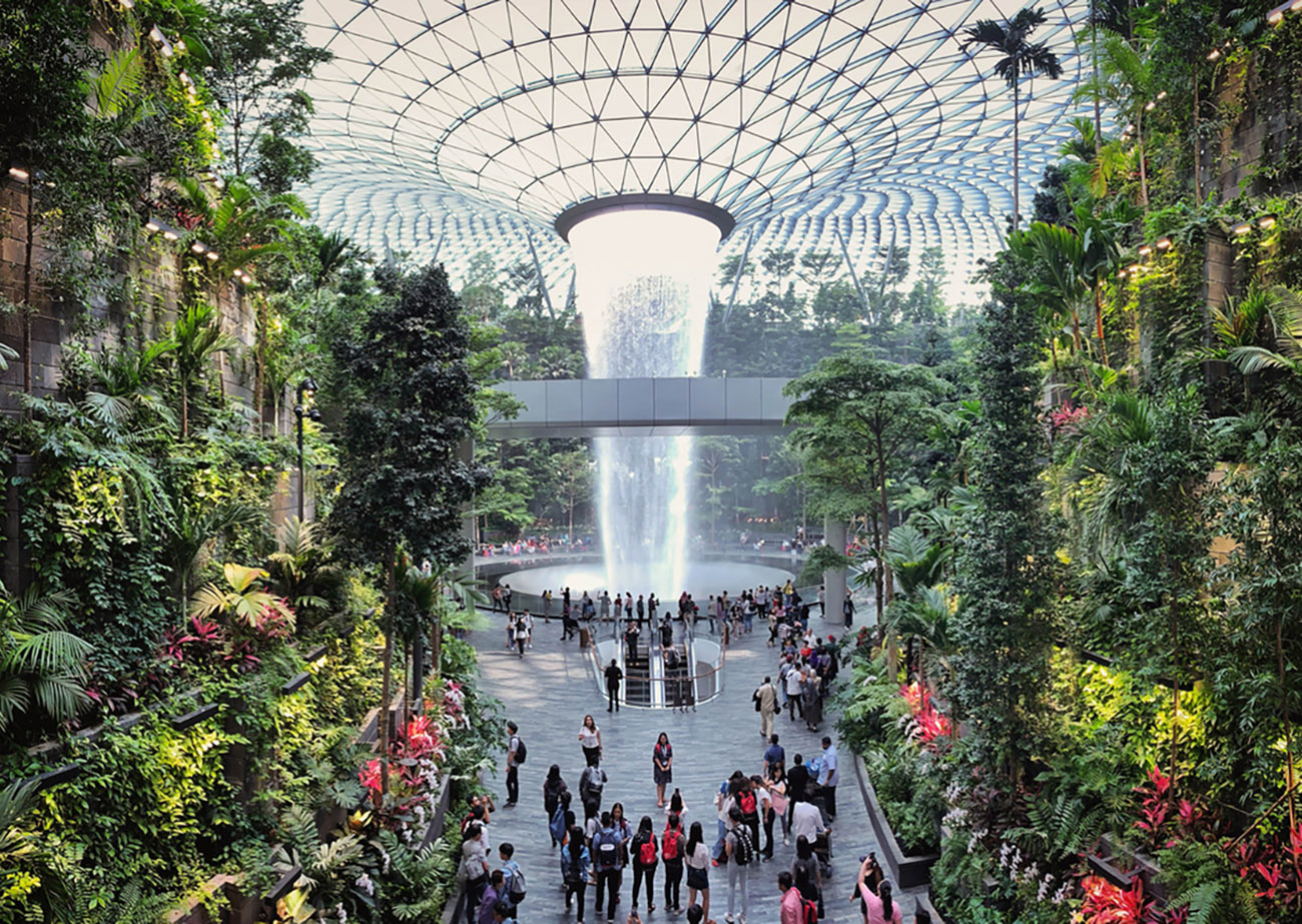 Jewel Changi Airport, Singapore - 5th August, 2019: Visitors tour around the Rain Vortex inside the Jewel area at Changi Airport. It's the world's tallest waterfall at 130 ft in height and surrounded by a four-storey terraced forest. The Jewel complex and waterfall was designed by Moshe Safdie.