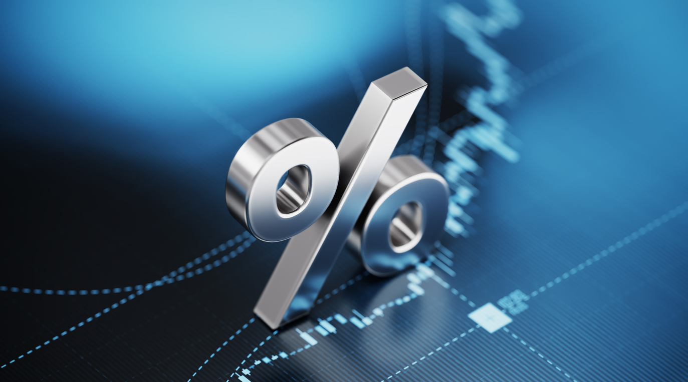Percentage sign sitting over blue financial graph background. Selective focus. Horizontal composition with copy space. Stock market and finance concept.
