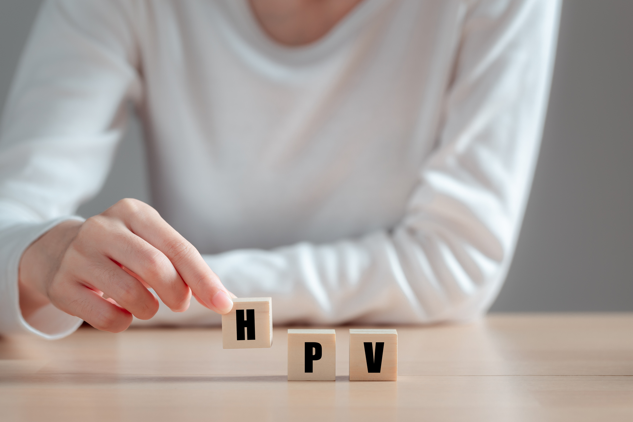 HPV (Human Papillomavirus) acronym on wood block, Asian woman  holding wooden block, viruses Some strains infect genitals and can cause cervical cancer. Women health concept.