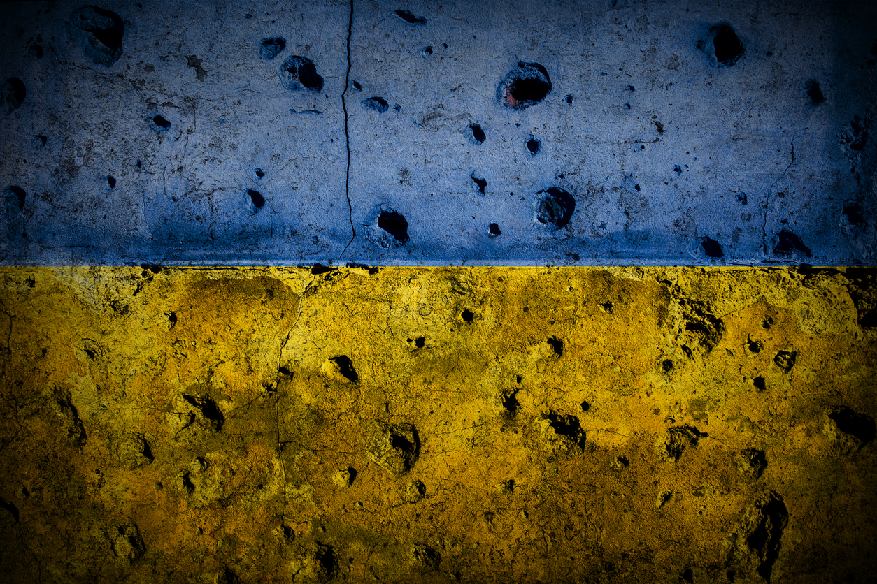 Wall of a house damaged by war in colors of Ukraine