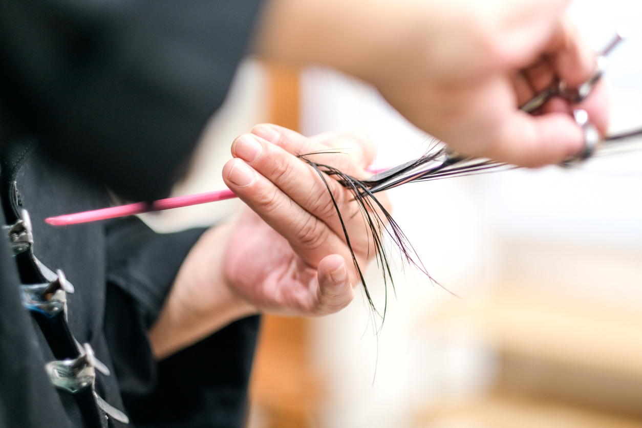 Hairdresser cutting woman's hair in hair salon