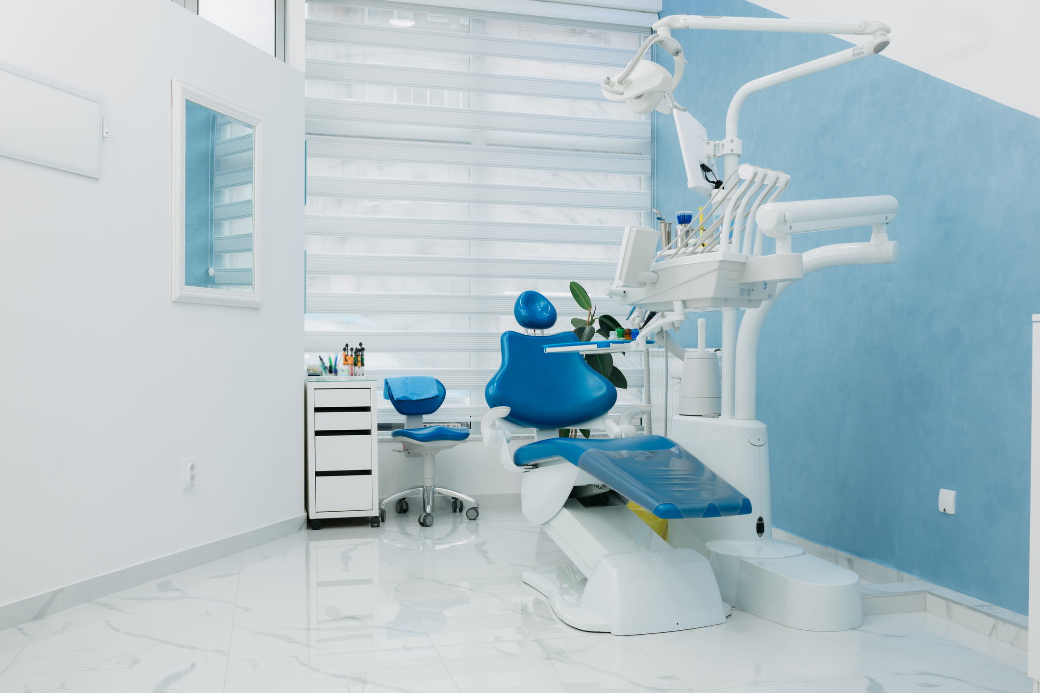 Clean and modern dentist office with a dentist chair and equipment, neatly arranged room, no people
