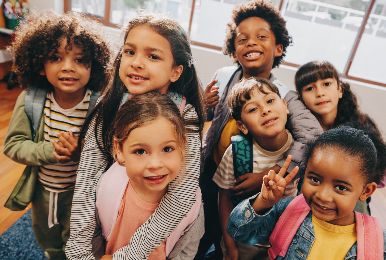 Class selfie in an elementary school. Kids taking a picture together in a co-ed school. Group of elementary school children feeling excited to be back at school.