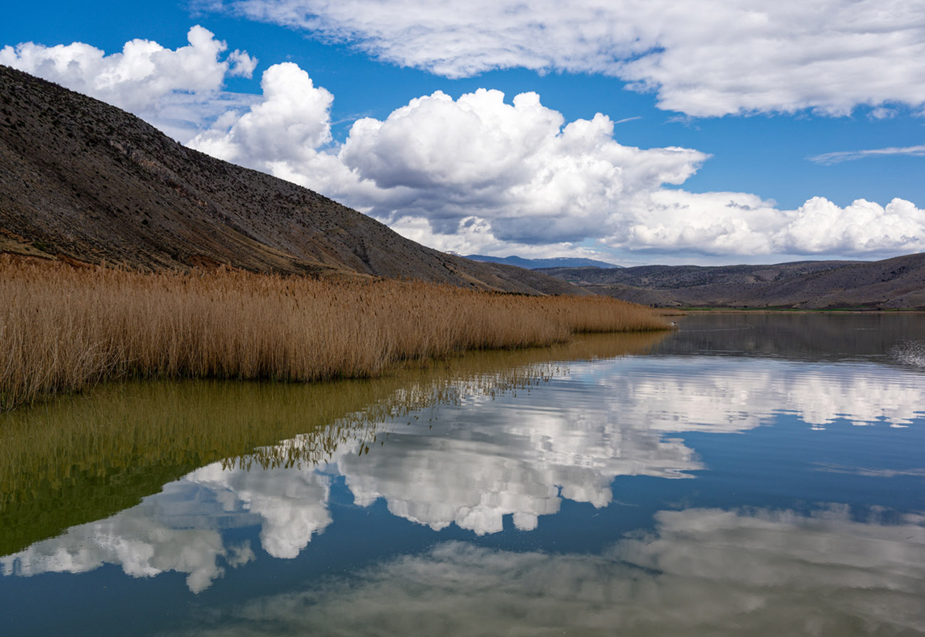 Cloudscape with reflections at the Petron Lake in northern Greece