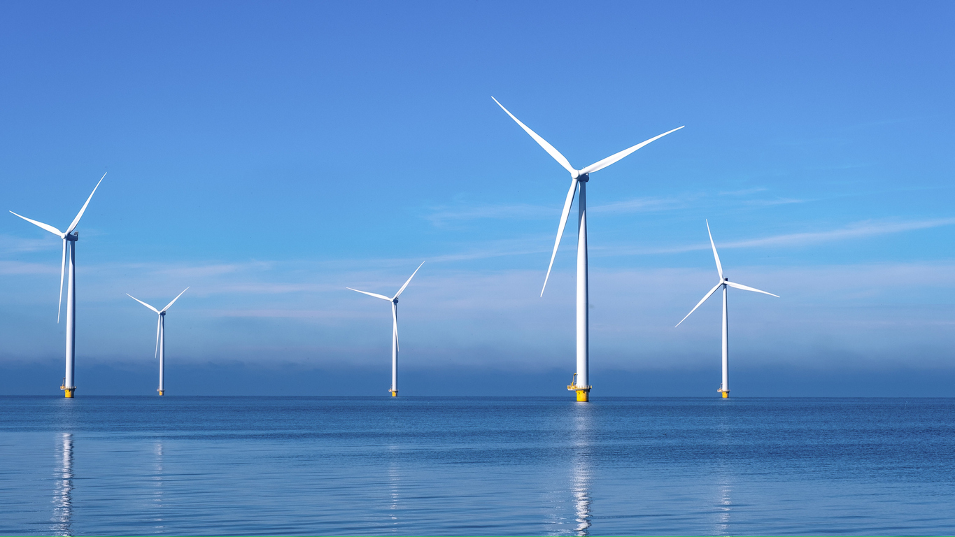 Windmill park with clouds and a blue sky, wind mill turbines in the ocean aerial view of a wind farm in the Nehterlands production clean energy