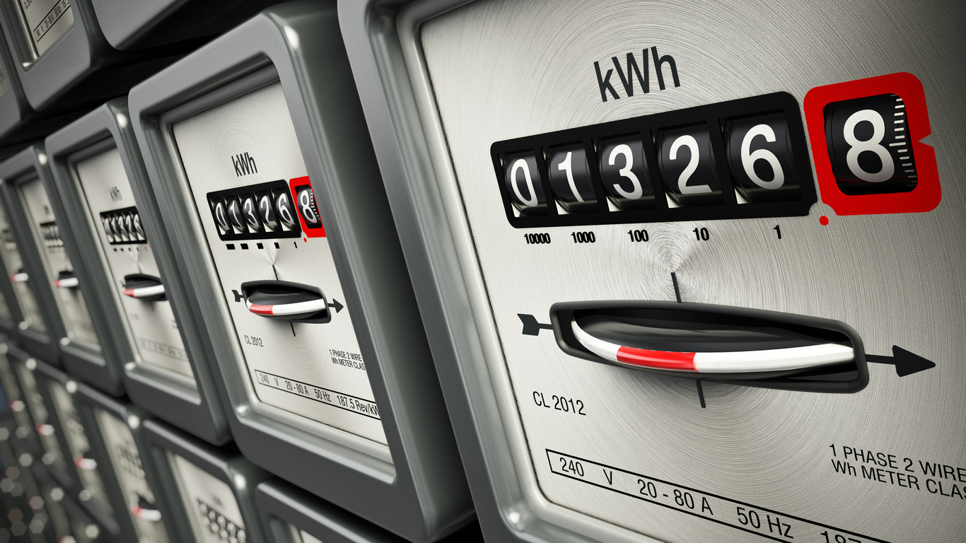 Electric meters in a row standing on the wall.