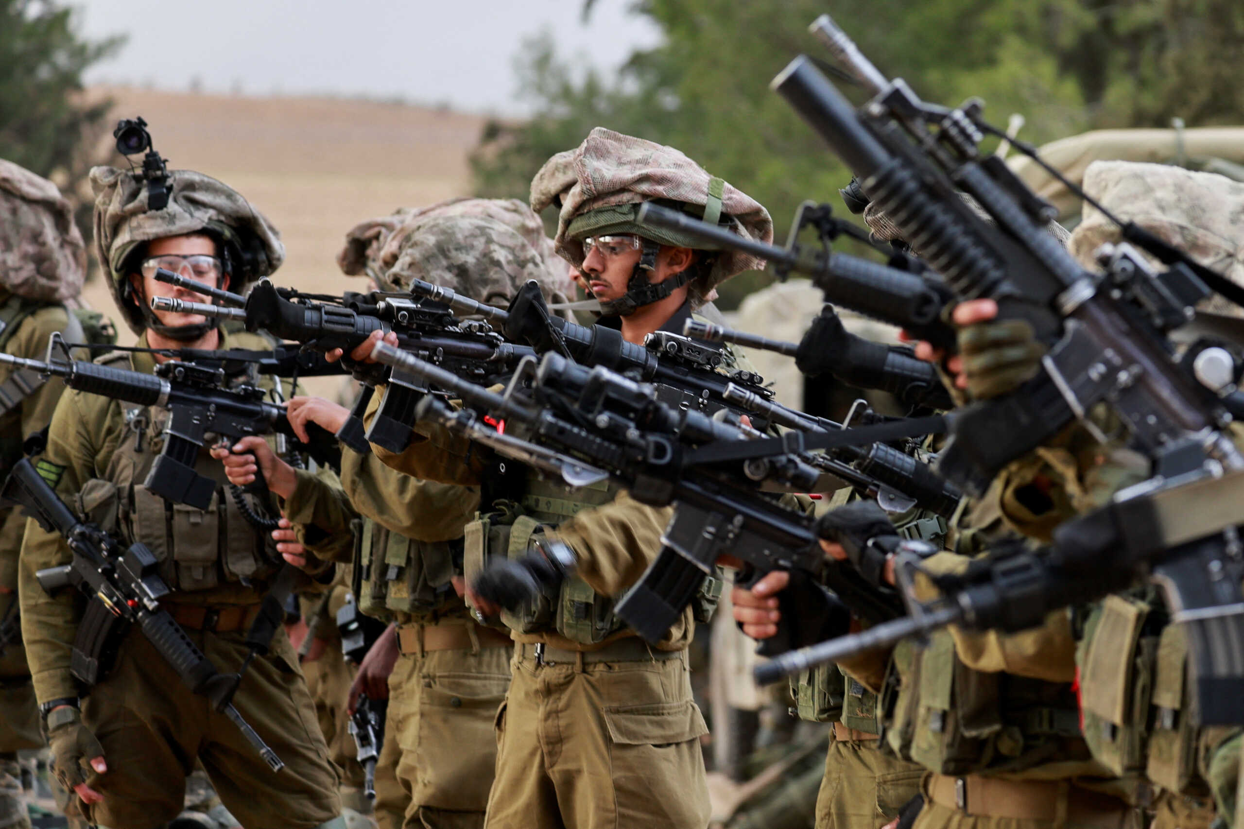 Israeli soldiers gather on the Israeli side of the Israel-Gaza border, amid the ongoing conflict between Israel and the Palestinian Islamist group Hamas, as seen from southern Israel, December 12, 2023. REUTERS