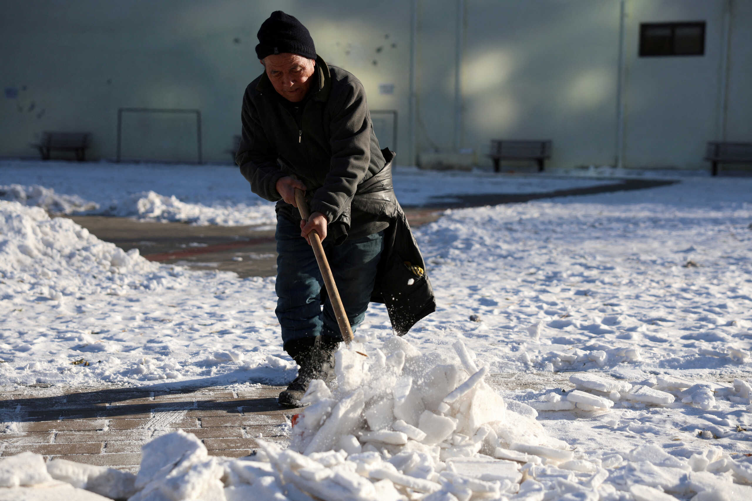 FILE PHOTO: A worker clears snow at a park during winter solstice in Beijing, China December 22, 2023. REUTERS