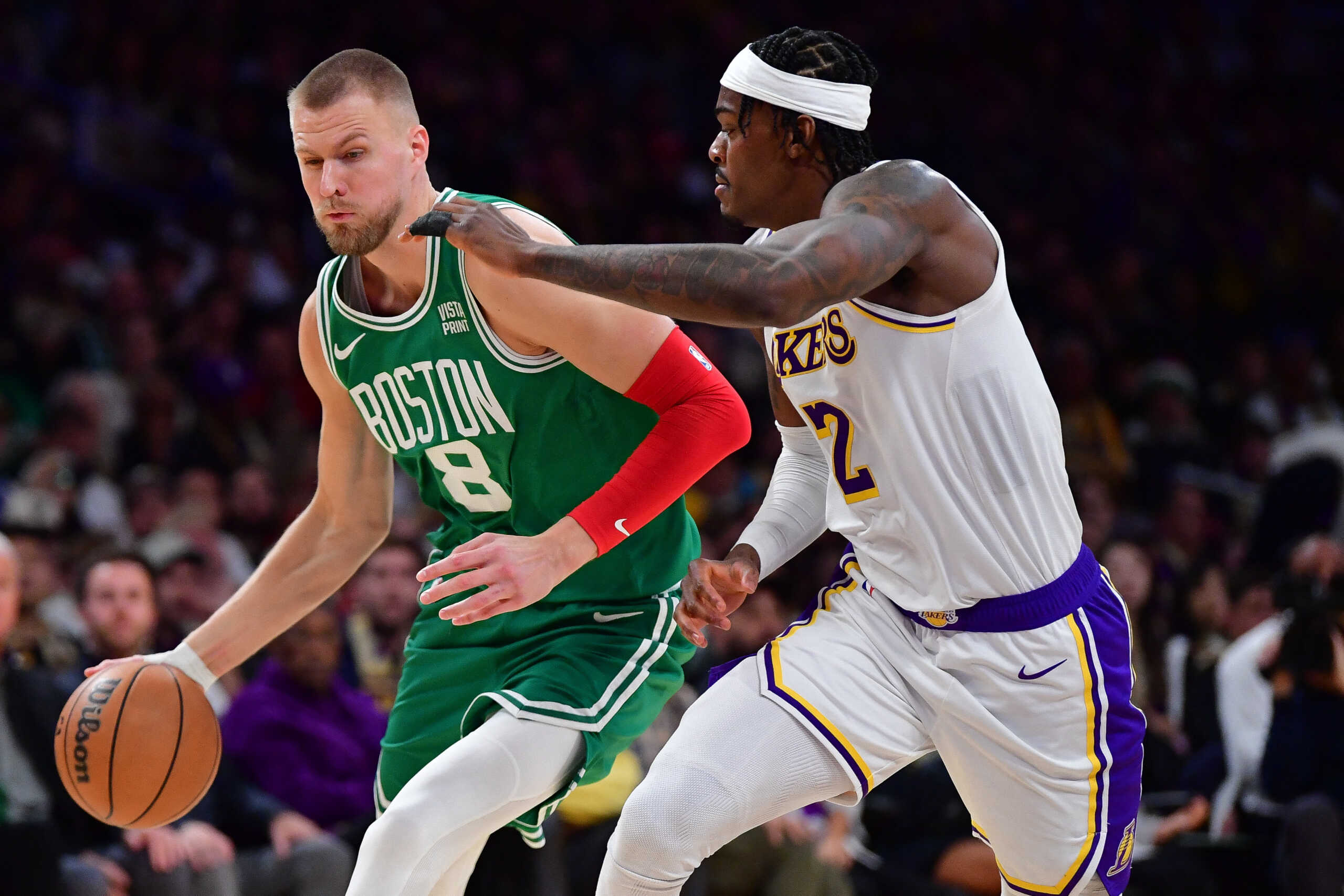 Dec 25, 2023; Los Angeles, California, USA; Boston Celtics center Kristaps Porzingis (8) moves to the basket against Los Angeles Lakers forward Jarred Vanderbilt (2) during the second half at Crypto.com Arena. Mandatory Credit: Gary A. Vasquez-USA TODAY Sports