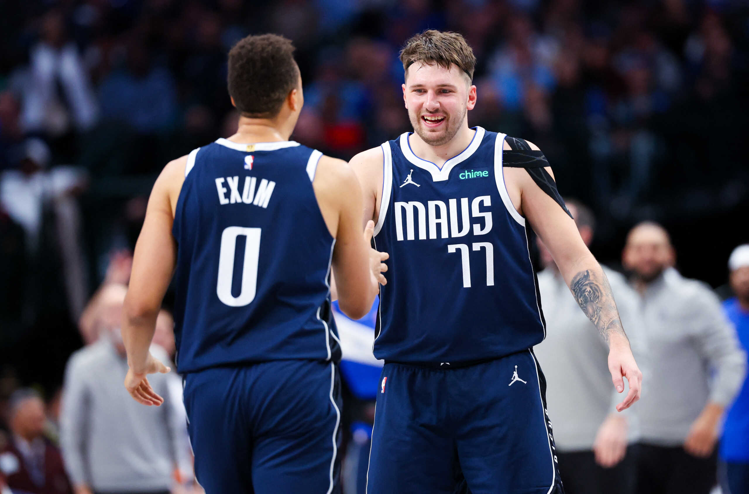 Dec 23, 2023; Dallas, Texas, USA;  Dallas Mavericks guard Luka Doncic (77) celebrates with Dallas Mavericks guard Dante Exum (0) during the second half against the San Antonio Spurs at American Airlines Center. Mandatory Credit: Kevin Jairaj-USA TODAY Sports