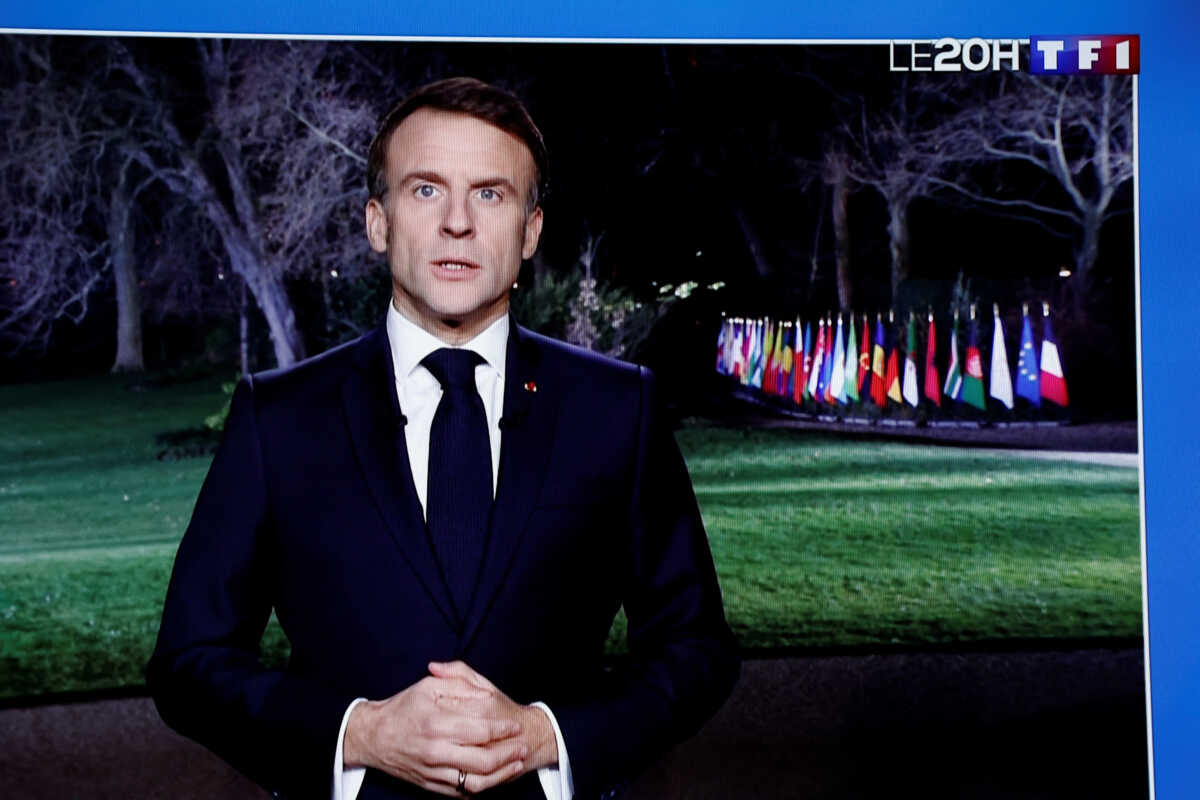 French President Emmanuel Macron is seen on a television screen as he delivers his New Year's speech to the nation at the Elysee Palace in Paris, France, December 31, 2023. REUTERS