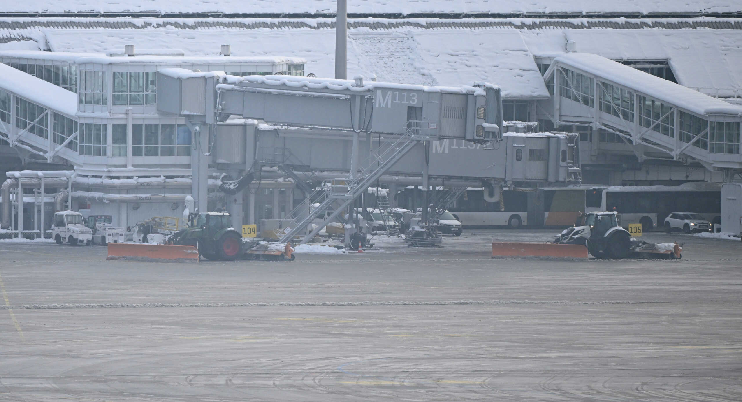 Snowploughs clean the tarmac at the terminal as Munich Airport has cancelled all incoming and outgoing flights until 12 p.m. (1100GMT) due to a forecast for sleet in Munich, Germany, December 5, 2023.     REUTERS