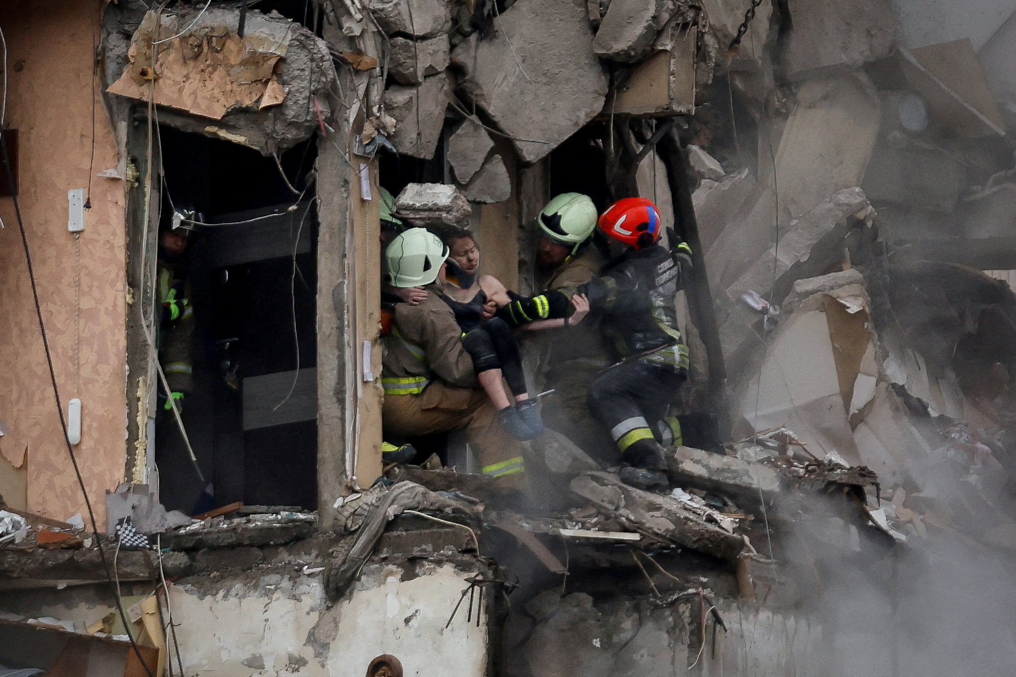 Emergency personnel evacuate a woman at the site where an apartment block was heavily damaged by a Russian missile strike, amid Russia's attack on Ukraine, in Dnipro, Ukraine January 15, 2023. REUTERS