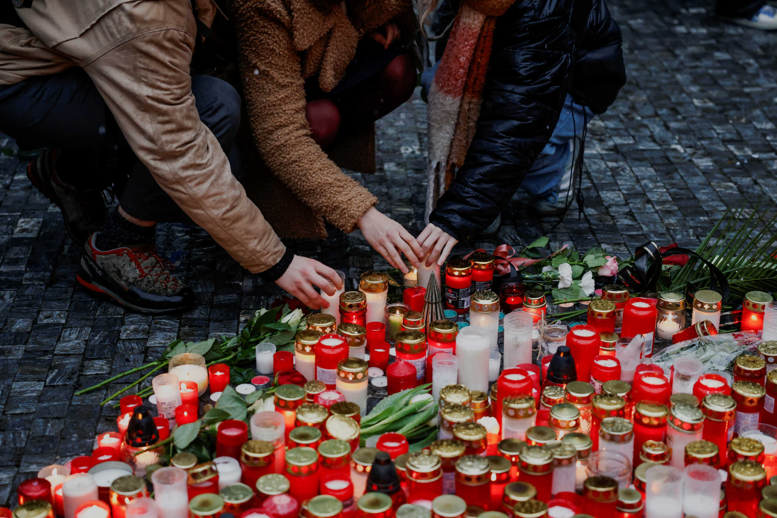 People light candles at a memorial during a vigil following a shooting at one of Charles University's buildings in Prague, Czech Republic, December 22, 2023. REUTERS