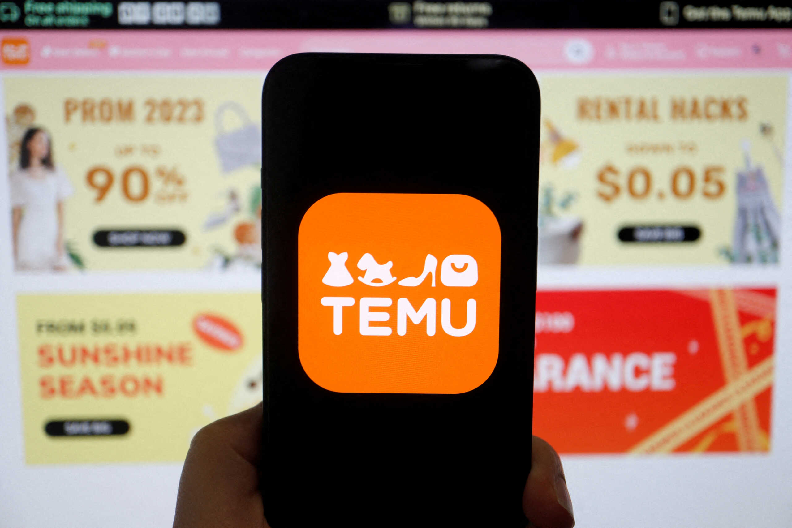 FILE PHOTO: The logo of Temu, an e-commerce platform owned by PDD Holdings, is seen on a mobile phone displayed in front of its website, in this illustration picture taken April 26, 2023. REUTERS