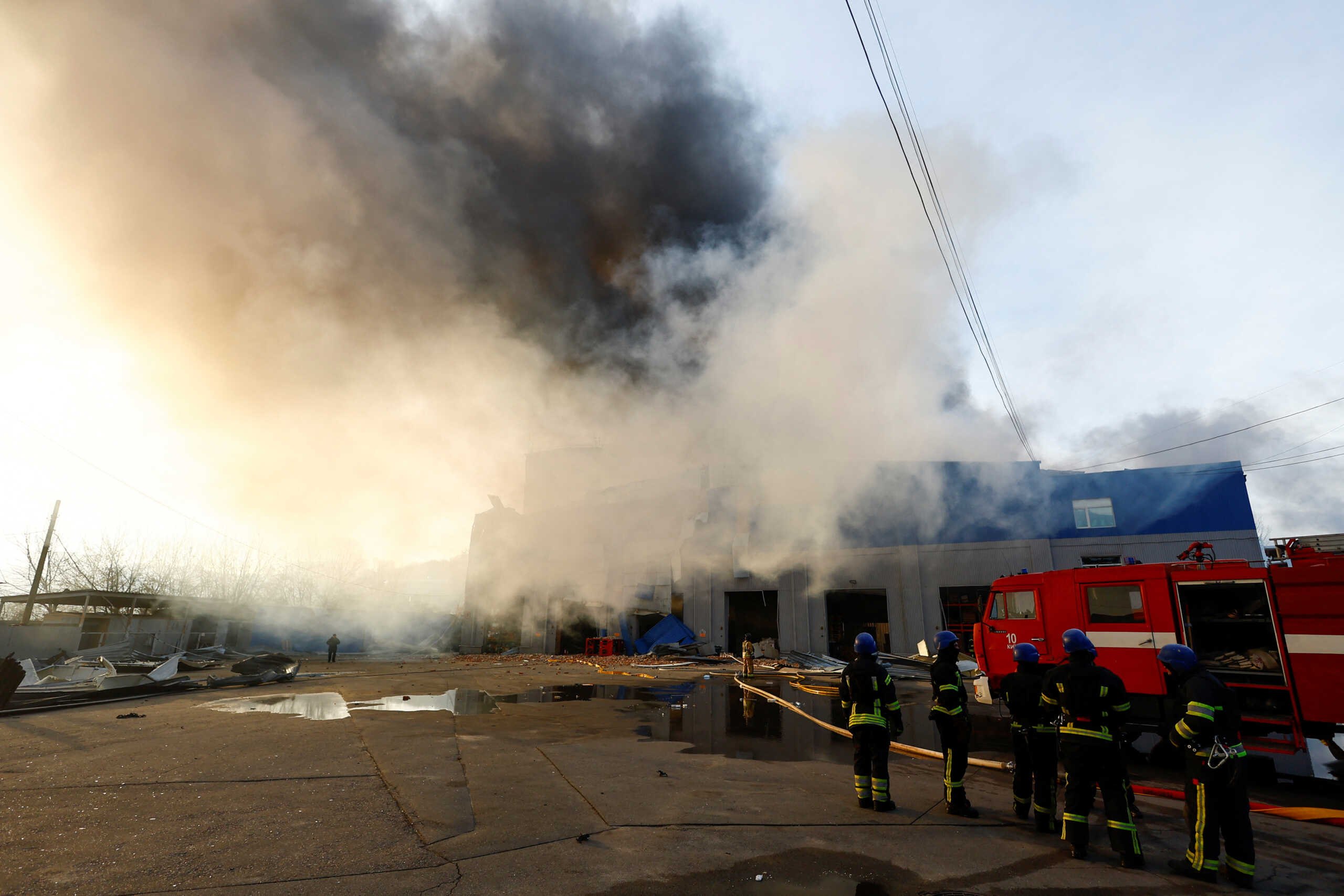 Firefighters stand infront of a warehouse heavily damaged during a Russian missile strike, amid Russia's attack on Ukraine, in Kyiv, Ukraine December 29, 2023. REUTERS