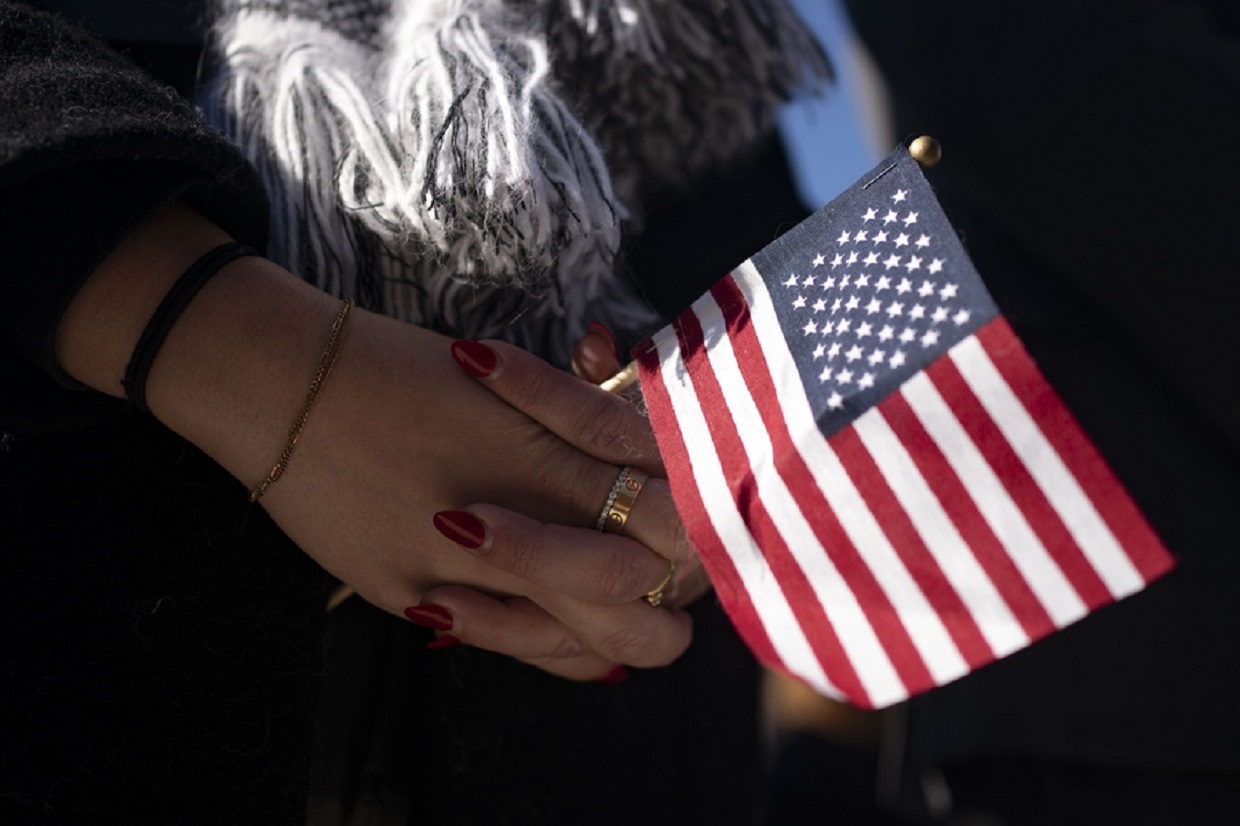 epa10970696 A woman holds an American flag during a National Veterans Day Observance ceremony at the Arlington National Cemetery in Arlington, Virginia, USA, 11 November 2023. The Veterans Day National Ceremony is held annually on 11 November at Arlington National Cemetery.  EPA
