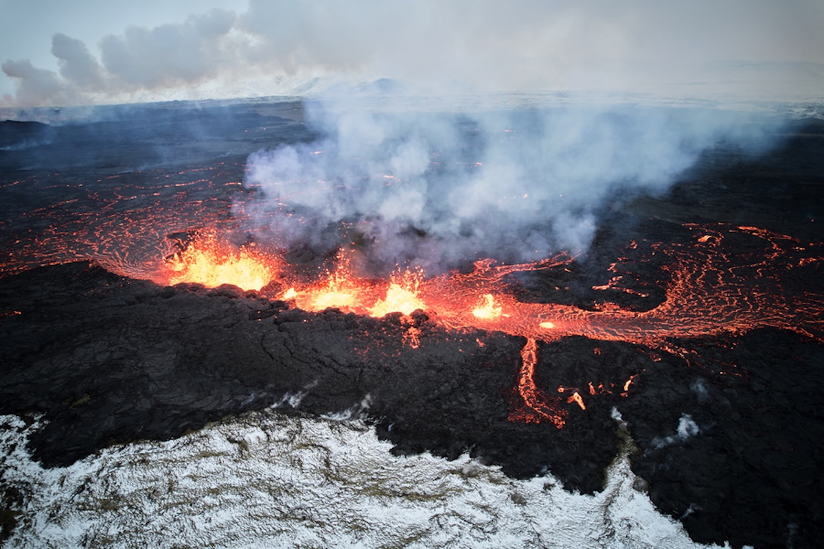 epa11037728 An aerial view taken with a drone shows lava and smoke spewing from a volcanic fissure during an eruption, near the town of Grindavik, in the Reykjanes peninsula, southwestern Iceland, 19 December 2023. The Icelandic Meteorological Office (IMO) announced the start of a volcanic fissure eruption near the Sundhnuka crater, north-east of Grindavik, on the night of 18 December, following weeks of intense earthquake activity in the area. The power and seismic activity of the eruption have decreased over time, IMO reported on 19 December, adding that since the eruption began, about 320 earthquakes have been recorded.  EPA