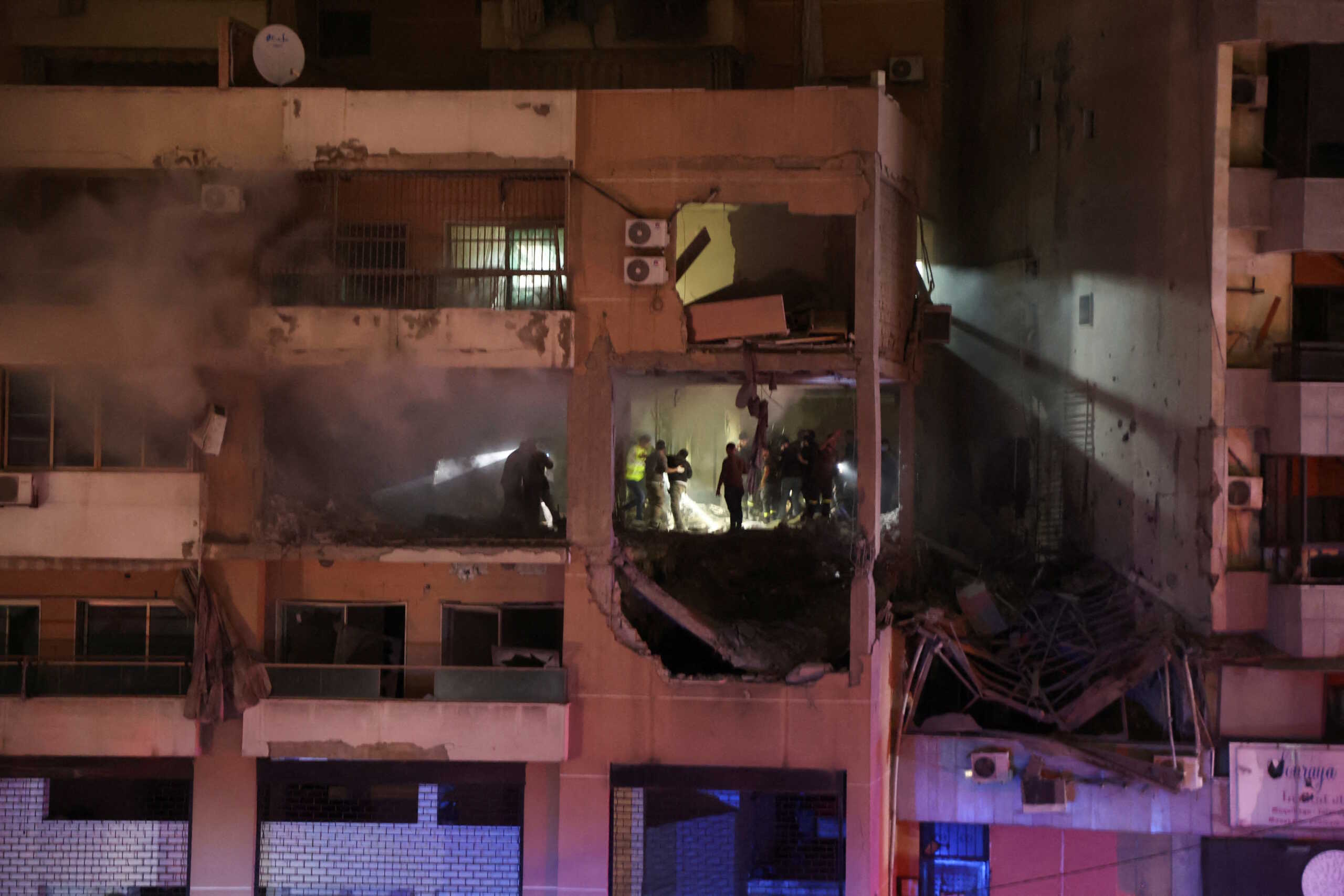 People stand at a damaged building following an explosion, in what security sources say is an Israeli drone strike, at the Beirut suburb of Dahiyeh, Lebanon January 2, 2024. REUTERS