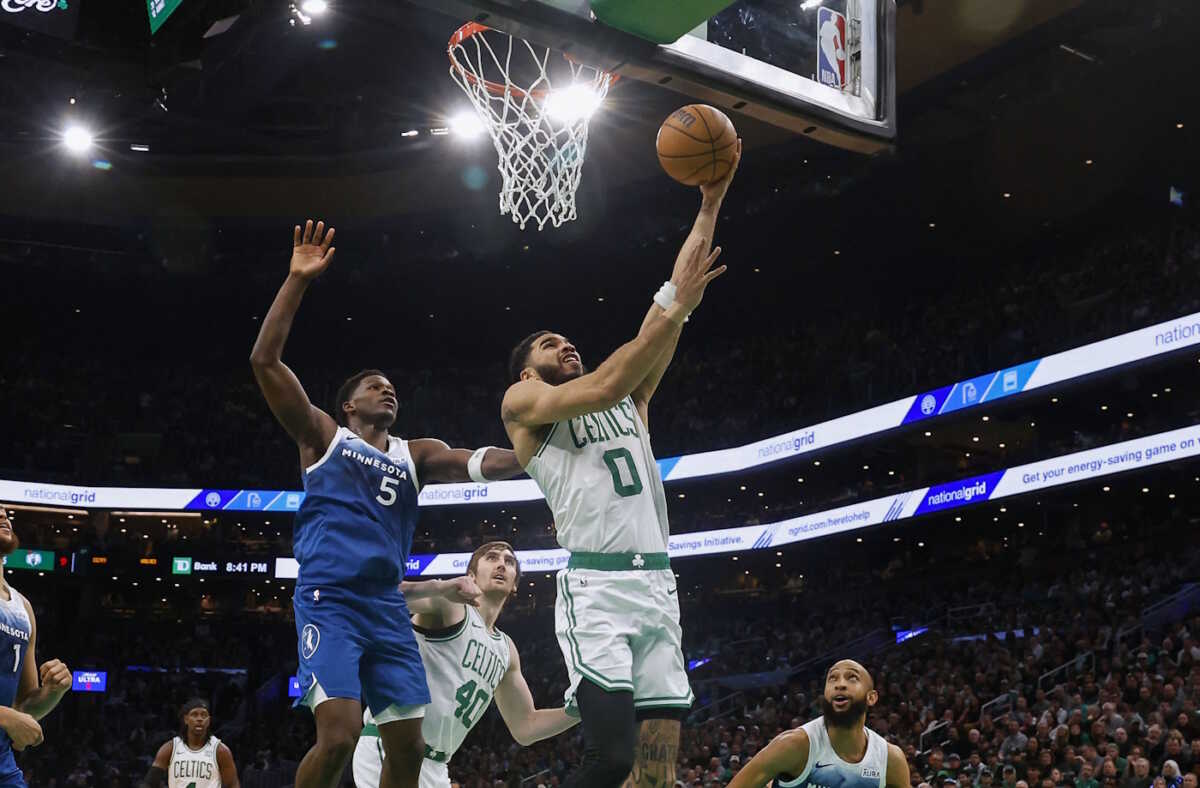 Jan 10, 2024; Boston, Massachusetts, USA; Boston Celtics forward Jayson Tatum (0) goes to the basket past Minnesota Timberwolves guard Anthony Edwards (5) during the second half at TD Garden. Mandatory Credit: Winslow Townson-USA TODAY Sports