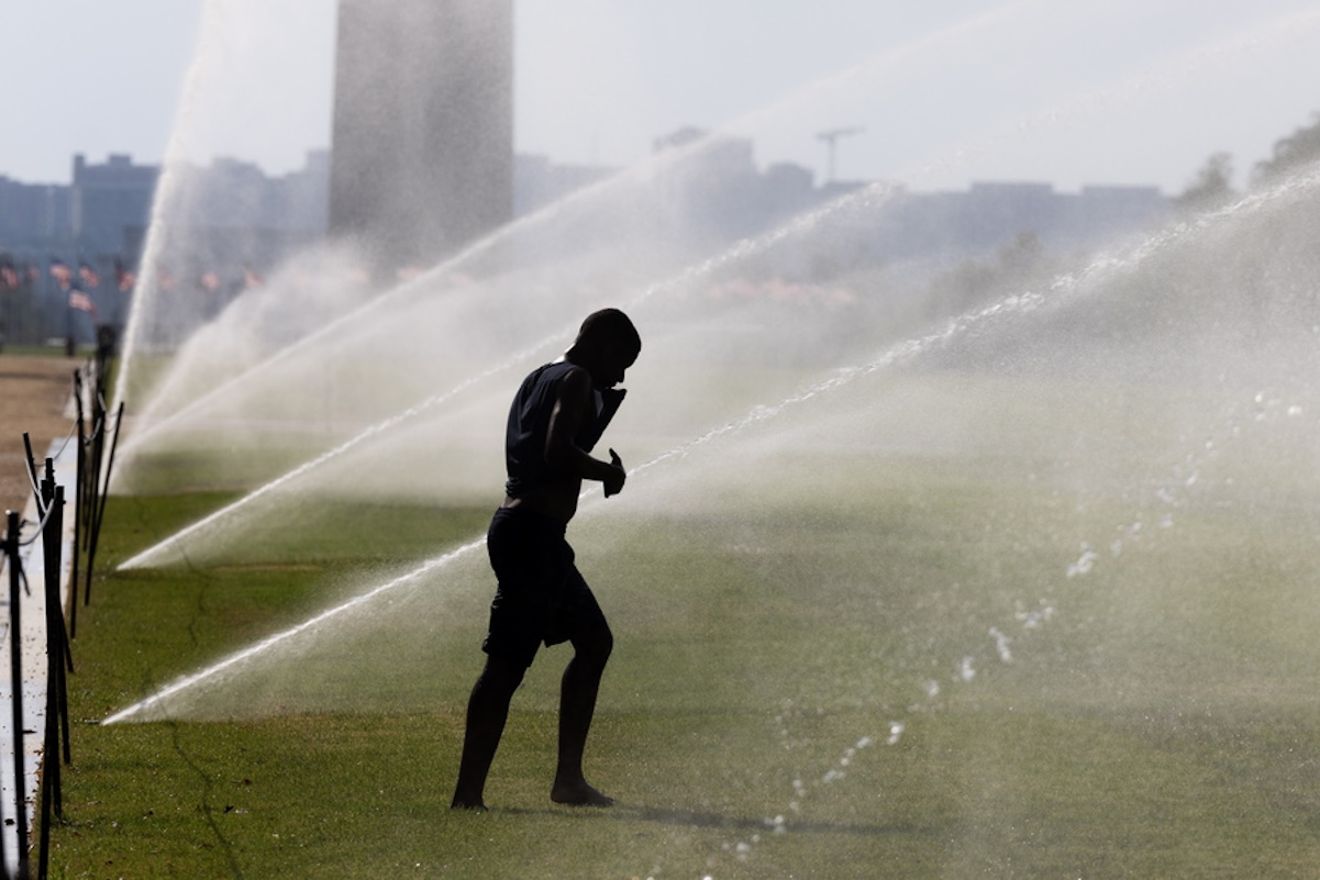 epa10849659 A person walks through sprinklers on the National Mall during a heat wave in Washington, DC, USA, 08 September 2023. Washington DC experienced a record-setting heat wave this week, with temperatures reaching 99 degrees (37.22 Celsius) 05 September. The United Nations World Meteorological Organization and the Copernicus climate change service issued a report stating that the three months between June and August 2023 have been the hottest ever recorded.  EPA