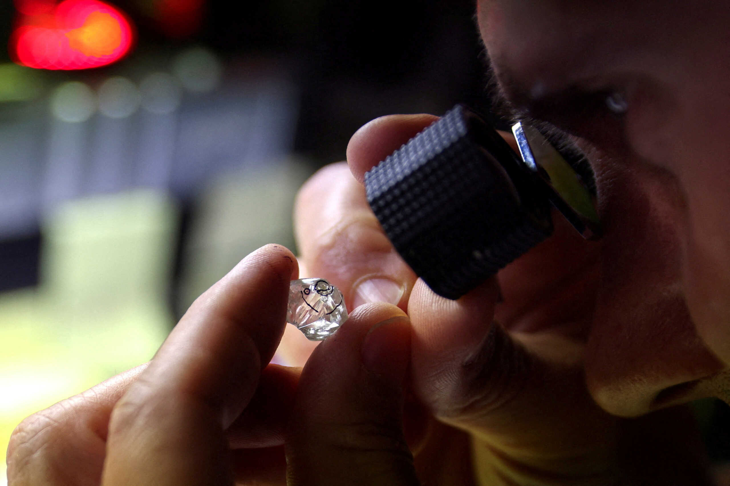 FILE PHOTO: An employee looks at a rough diamond at "Flanders Manufacturing", as the G7 weighs a ban on Russian diamond imports to reduce revenues for Moscow's war in Ukraine, Antwerp, Belgium, October 30, 2023. REUTERS
