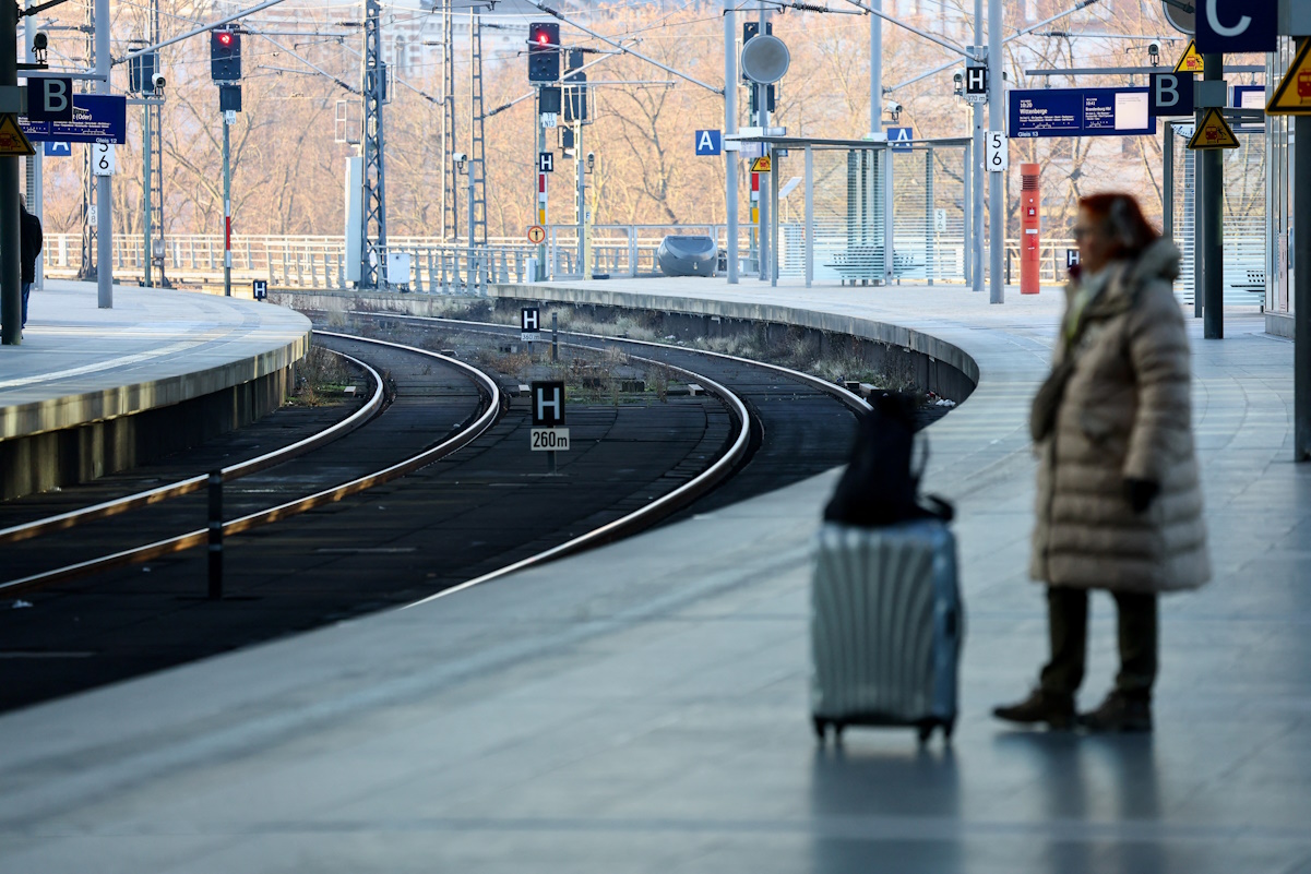 A passenger stands on a platform next to empty railway tracks at Berlin Hauptbahnhof main train station during a strike by Germany's GDL train drivers union, demanding wage increases and a shorter working week, in Berlin, Germany, January 10, 2024.  REUTERS