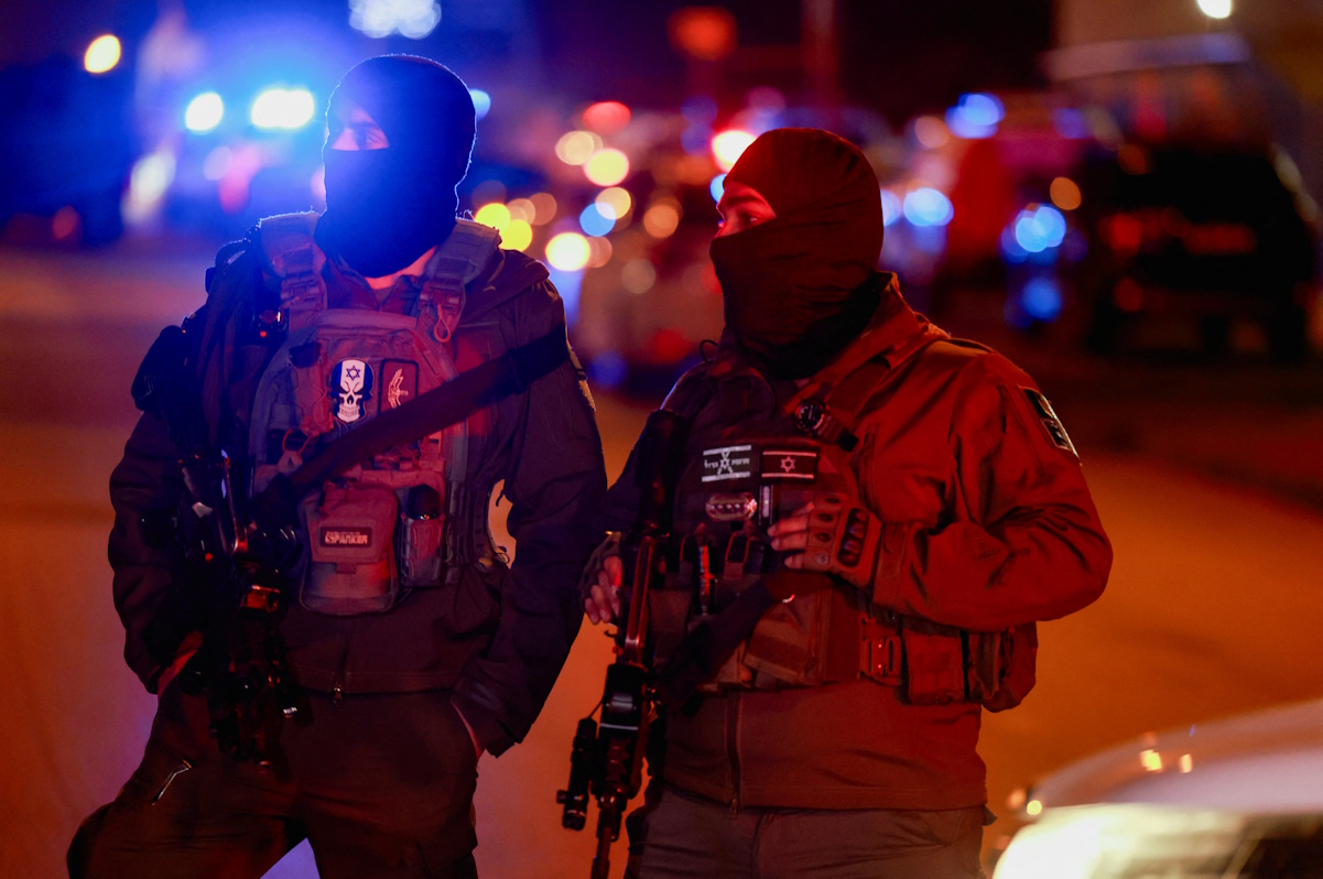 Members of the Israeli security forces stand guard at the scene following a suspected stabbing attack in Mishor Adumim, in the Israeli-occupied West Bank, December 31, 2023. REUTERS