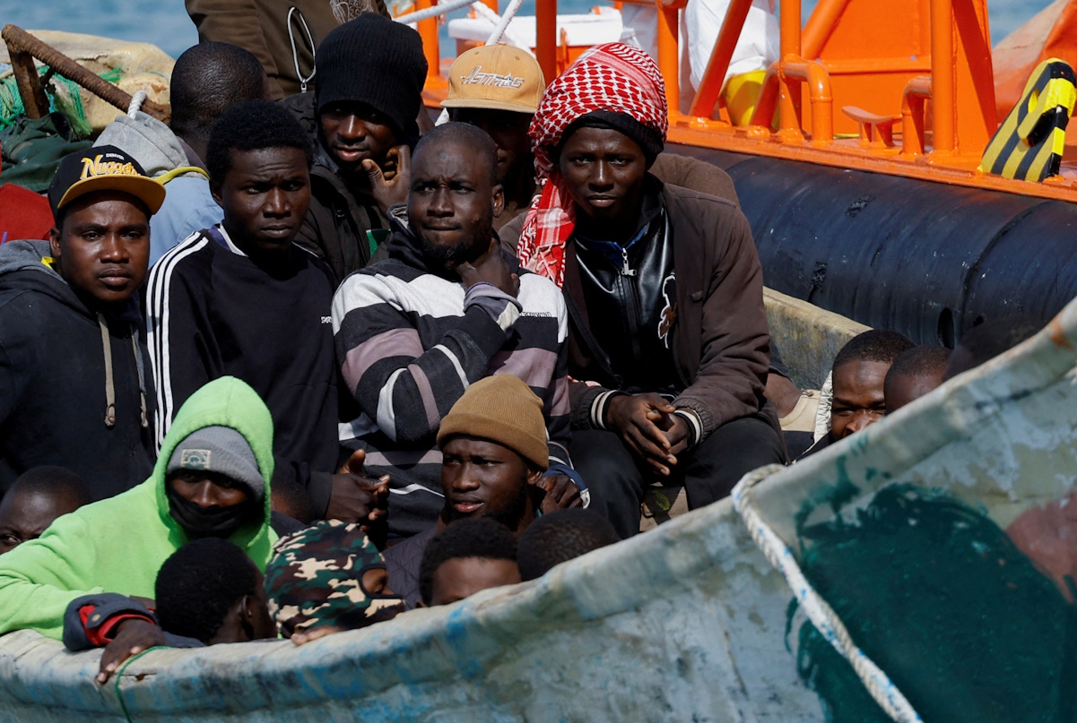 A group of migrants wait to disembark from a wooden boat after being rescued by a Spanish coast guard vessel in the port of Arguineguin, on the island of Gran Canaria, Spain, January 18, 2024. REUTERS