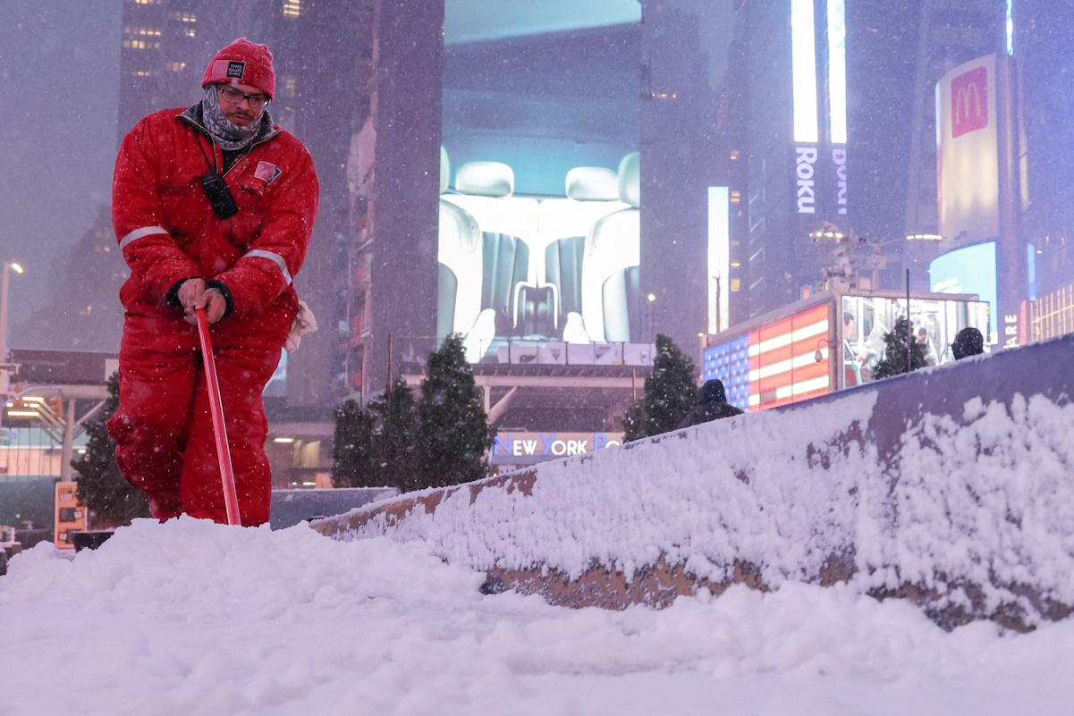 A worker clears snow in Times Square during the first snowfall in over 700 days in New York City, U.S., January 16, 2024. REUTERS