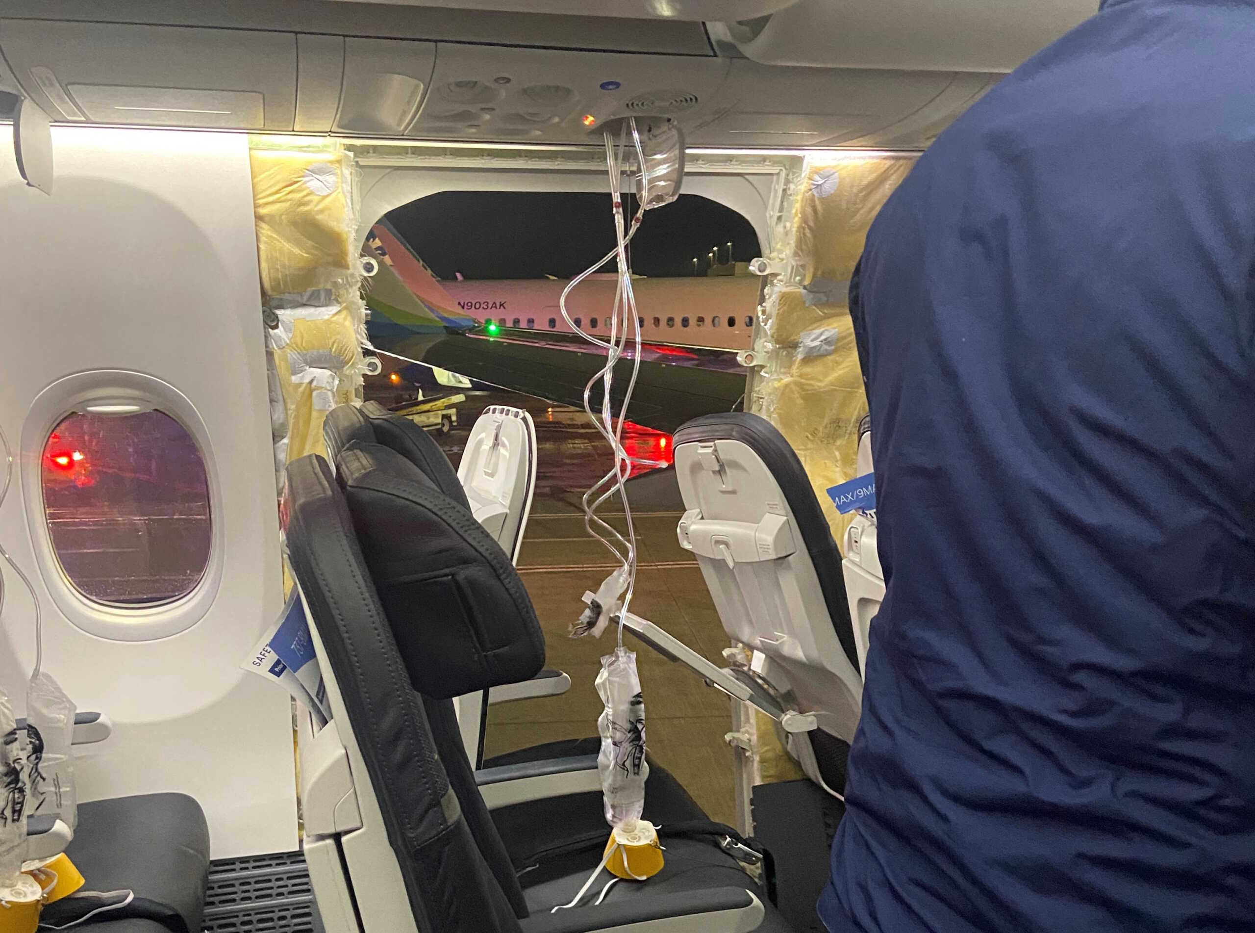 Passenger oxygen masks hang from the roof next to a missing window and a portion of a side wall of an Alaska Airlines Flight 1282, which had been bound for Ontario, California and suffered depressurization soon after departing, in Portland, Oregon, U.S., January 5, 2024 in this picture obtained from social media. Kyle Rinker via X