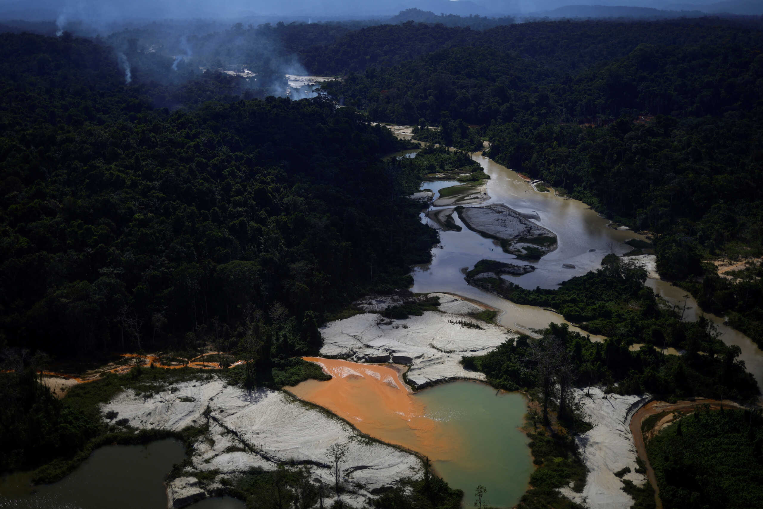An illegal mine is seen in the Couto de Magalhaes river during an operation by members of the Special Inspection Group from the Brazilian Institute of Environment and Renewable Natural Resources (IBAMA) against illegal mining in Yanomami Indigenous land, Roraima state, Brazil, December 3, 2023. The destruction of the rainforest was evident from gaping pits some five meters (16 ft) deep in mining sites cleared of trees, along with dozens of ponds where dredged sludge was pumped into rivers, turning pristine waters a bright orange from the mud.        REUTERS