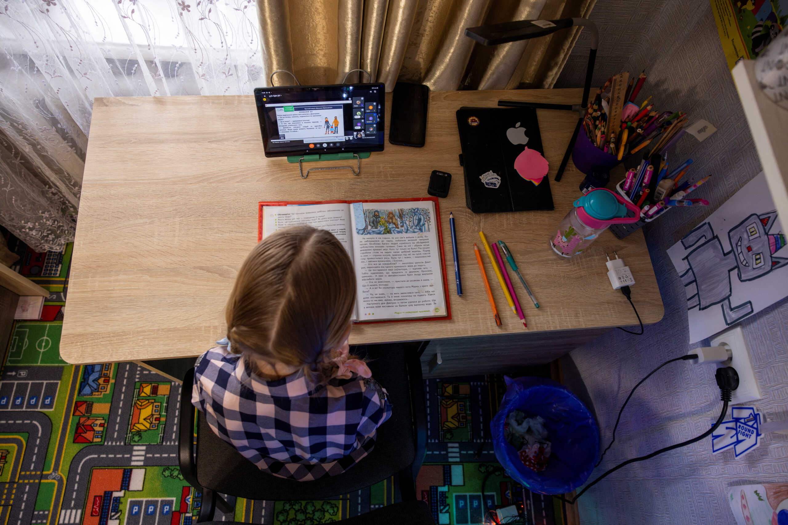 Ukrainian third-grader Arina Herasymova attends an online reading class in her bedroom in Sloviansk, amid Russia's attack on Ukraine, December 20, 2023. Ukrainian third-grade student Arina has had just over 1.5 months of in-class schooling because of the war that poses the regular threat of Russian air strikes on schools.  REUTERS