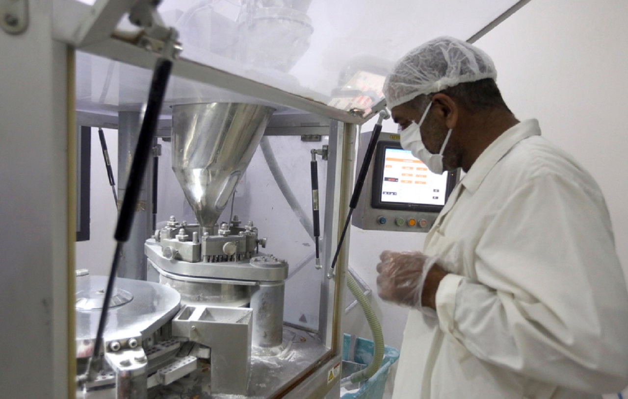 epa08643573 A laboratory technician stands next to drug-making machine at the laboratory of the Syrian Tamico Pharmaceutical Factory in the countryside of Damascus, Syria, 03 September 2020. The nationwide famous drug factory is producing Azithromycin tablets that are used with the antimalarial drug hydroxychloroquine as one of the treatments for patients with Covid-19, however a recent study revealed this combination may be associated with increased mortality.  EPA