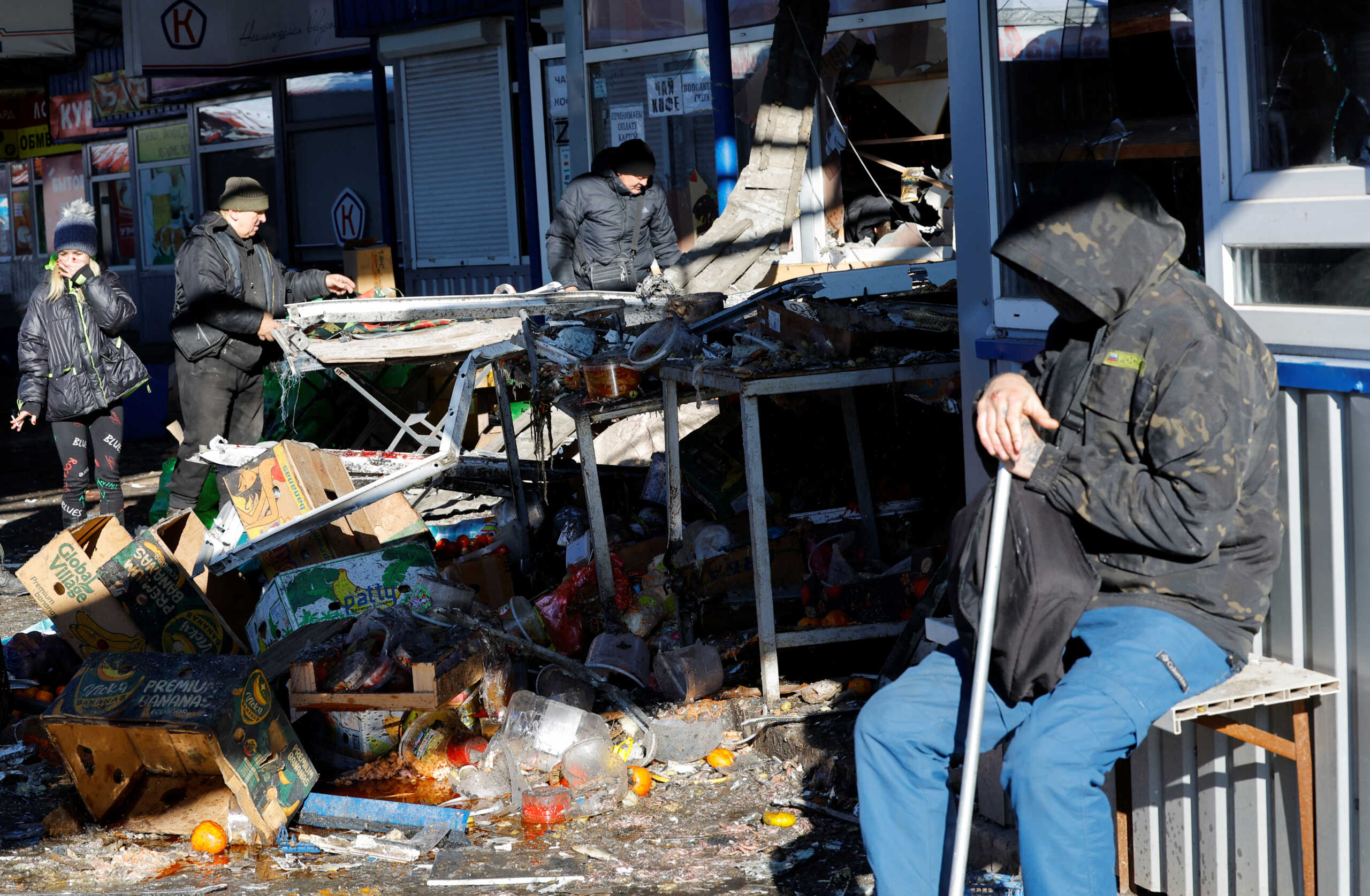 People remove debris at a food market following, what local Russian-installed authorities say, was a Ukrainian military strike in the course of Russia-Ukraine conflict in Donetsk, Russian-controlled Ukraine, January 21, 2024. REUTERS