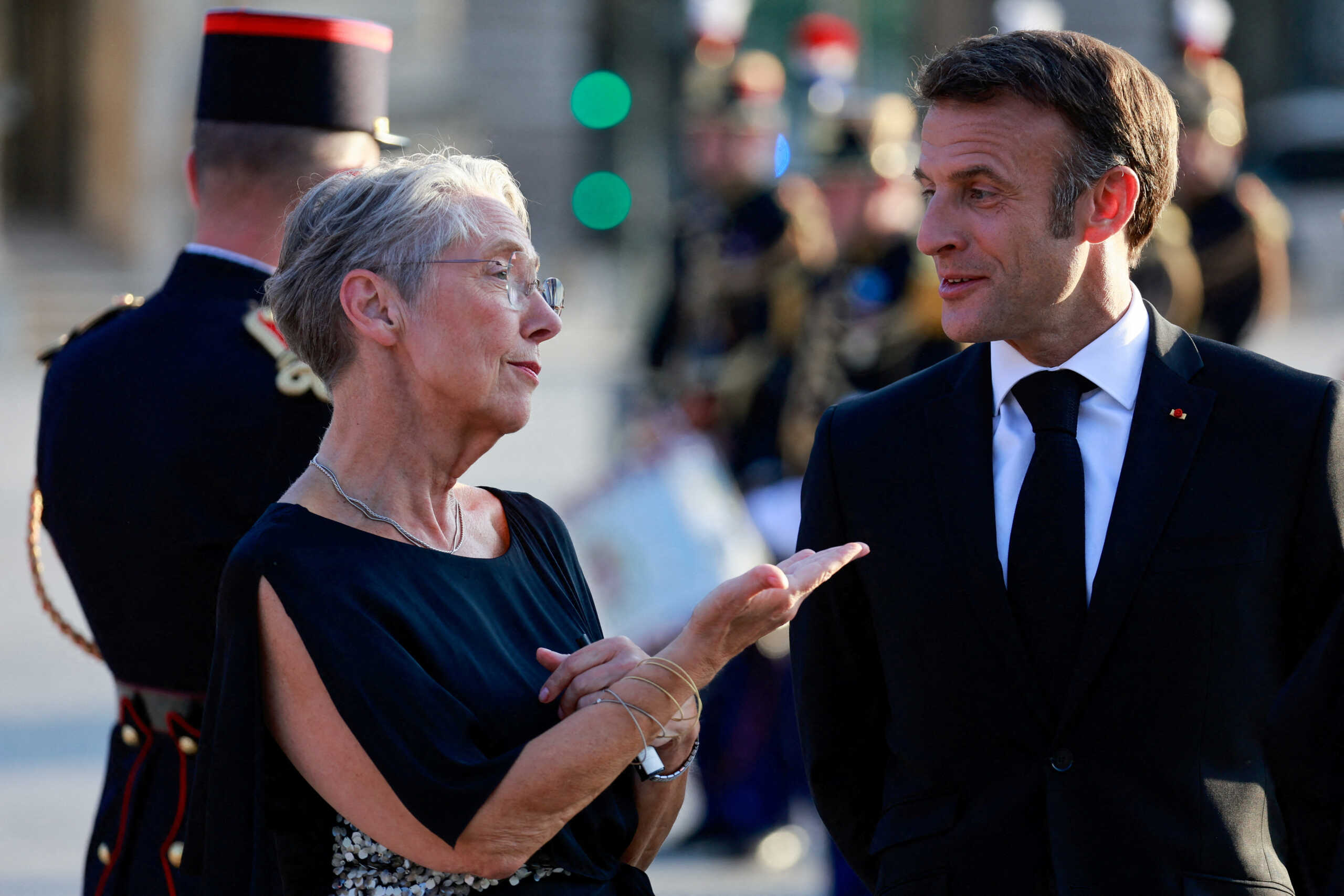 FILE PHOTO: French President Emmanuel Macron and Prime Minister Elisabeth Borne speak together as they arrive to a dinner held at the Louvre in Paris, France, July 14, 2023. REUTERS