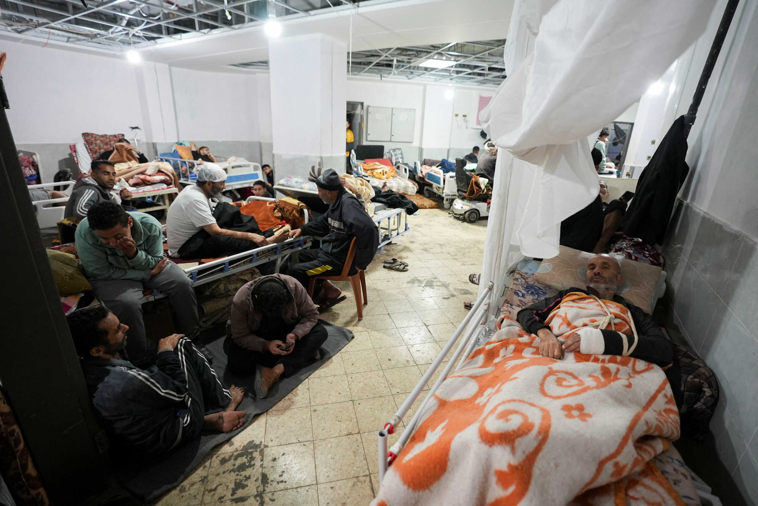 Palestinians wounded in Israeli strikes lie on beds as displaced people shelter at Shuhada Al-Aqsa Hospital, amid the ongoing conflict between Israel and Hamas, in Deir Al-Balah in the central Gaza Strip, January 3, 2024. REUTERS