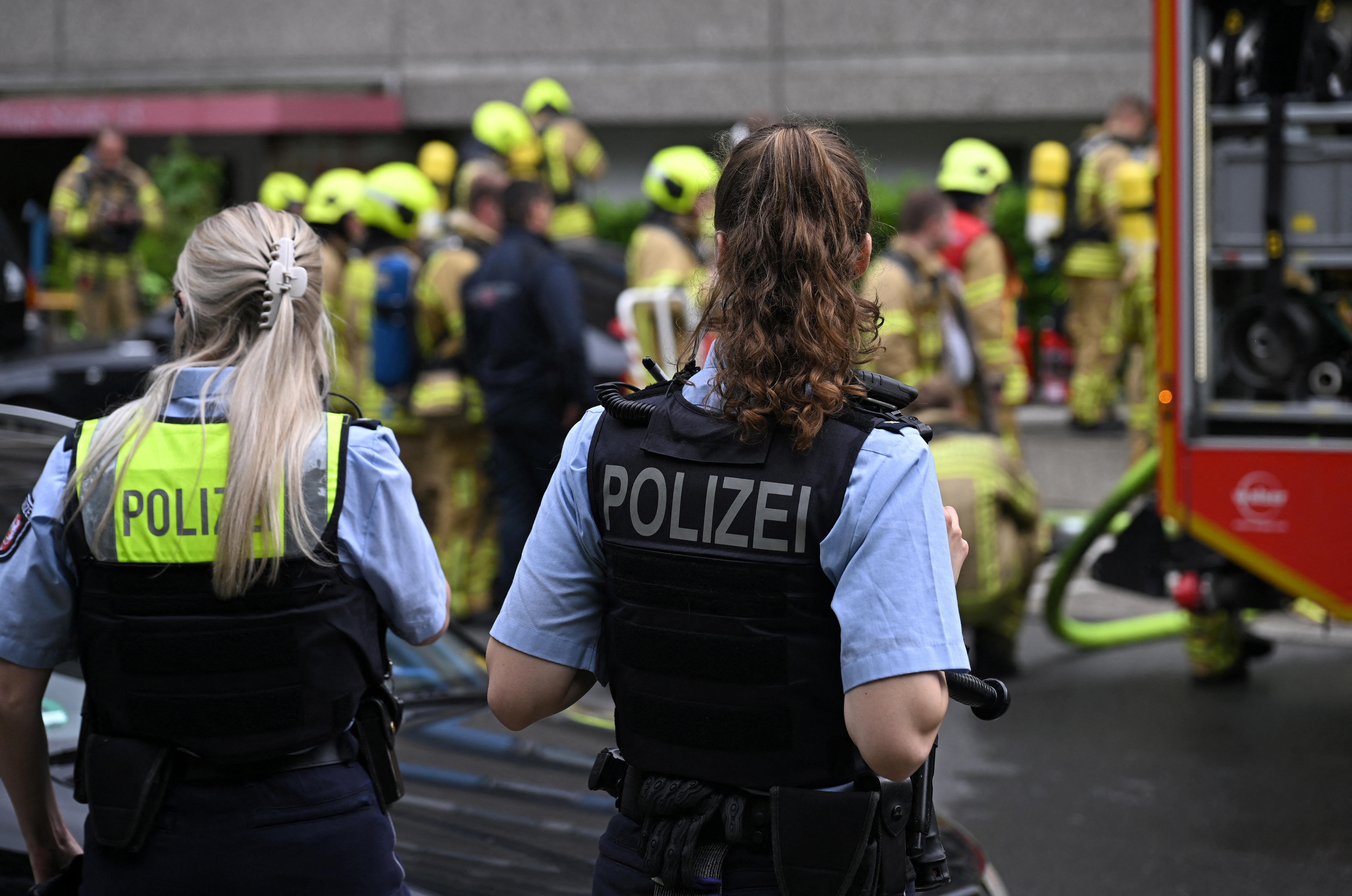 Firefighters gather as police looks on after two police officers and several firefighters were injured in an explosion at an apartment building in the western German town of Ratingen, Germany, May 11, 2023.     REUTERS