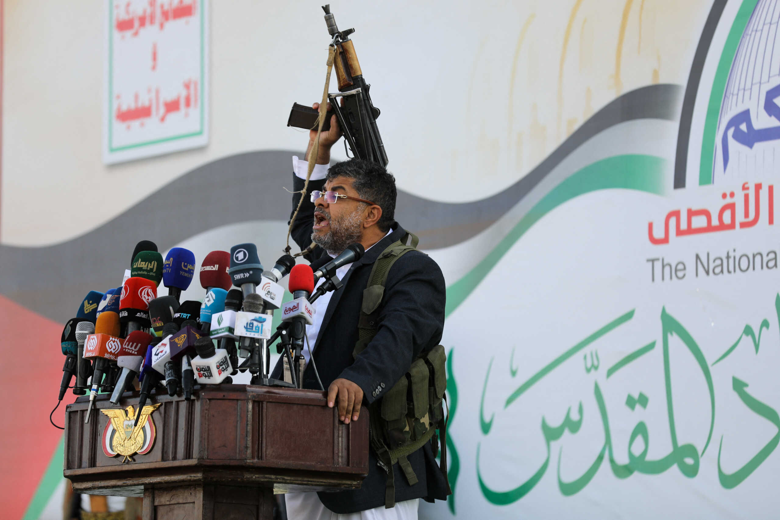 Mohammed Ali al-Houthi, a member of the Houthi supreme political council, speaks while holding a gun, as supporters of the Houthi movement rally to denounce air strikes launched by the U.S. and Britain on Houthi targets, in Sanaa, Yemen January 12, 2024. REUTERS