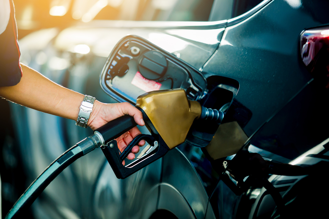 Hand refilling the car with fuel at the refuel station, the concept of fuel energy