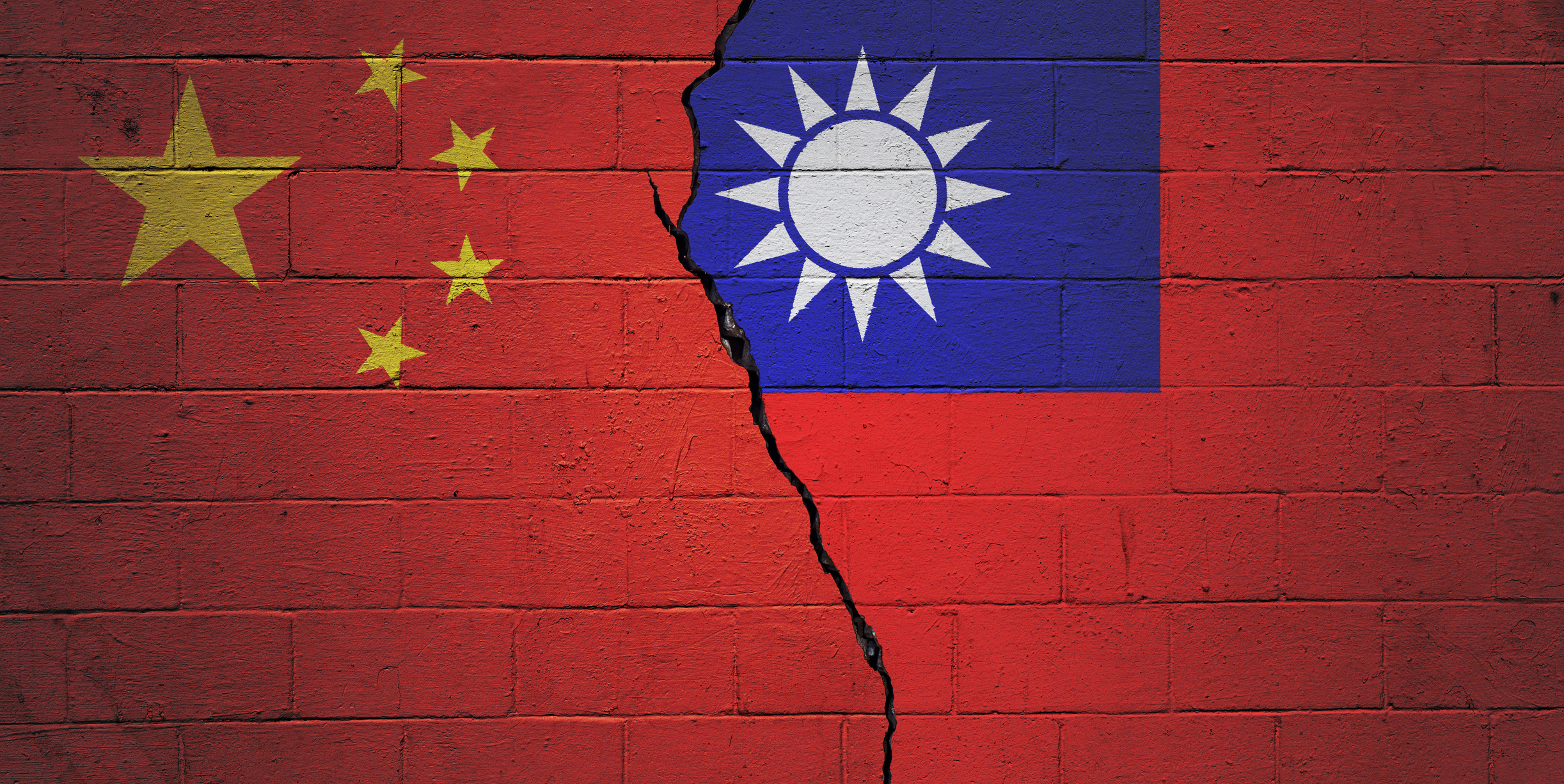 Cracked brick wall painted with an Chinese flag on the left and a Taiwanese flag on the right.