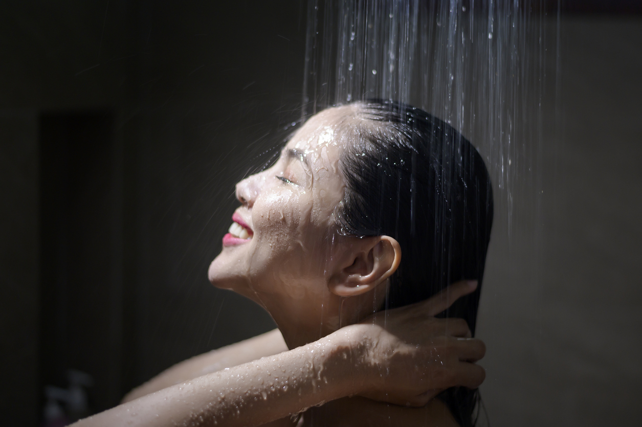 Young beautiful woman washing her hair in a bathroom at home