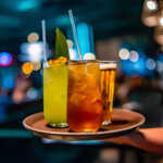 glasses alcohol cocktail set and beer on a waiter tray in bar