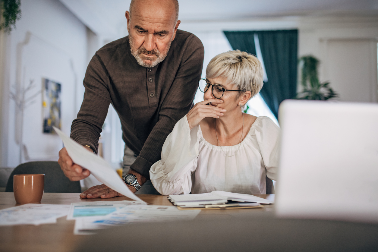 Couple calculating bills and taxes and home and trying to organise to pay them
