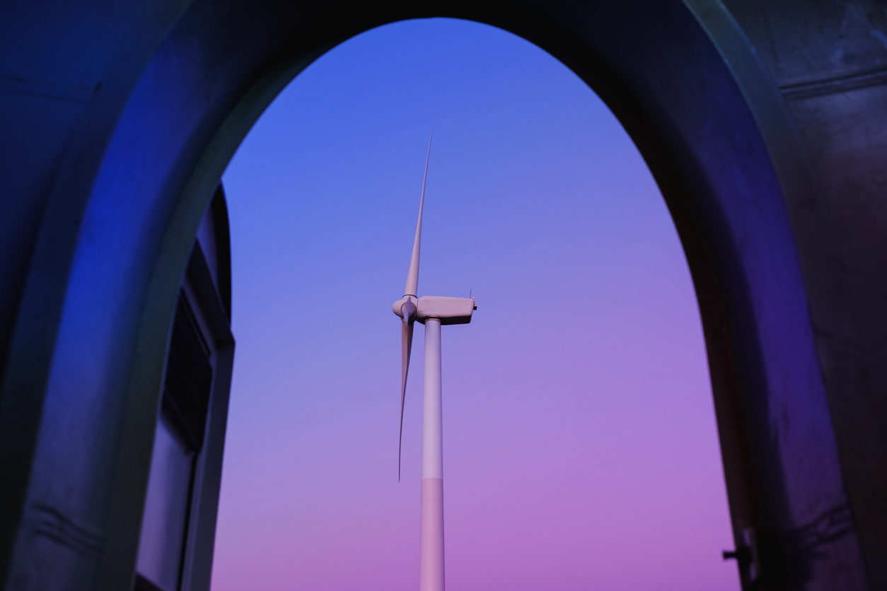 Open the door to the wind turbine, in a purple and blue twilight. Renewable energy concept.