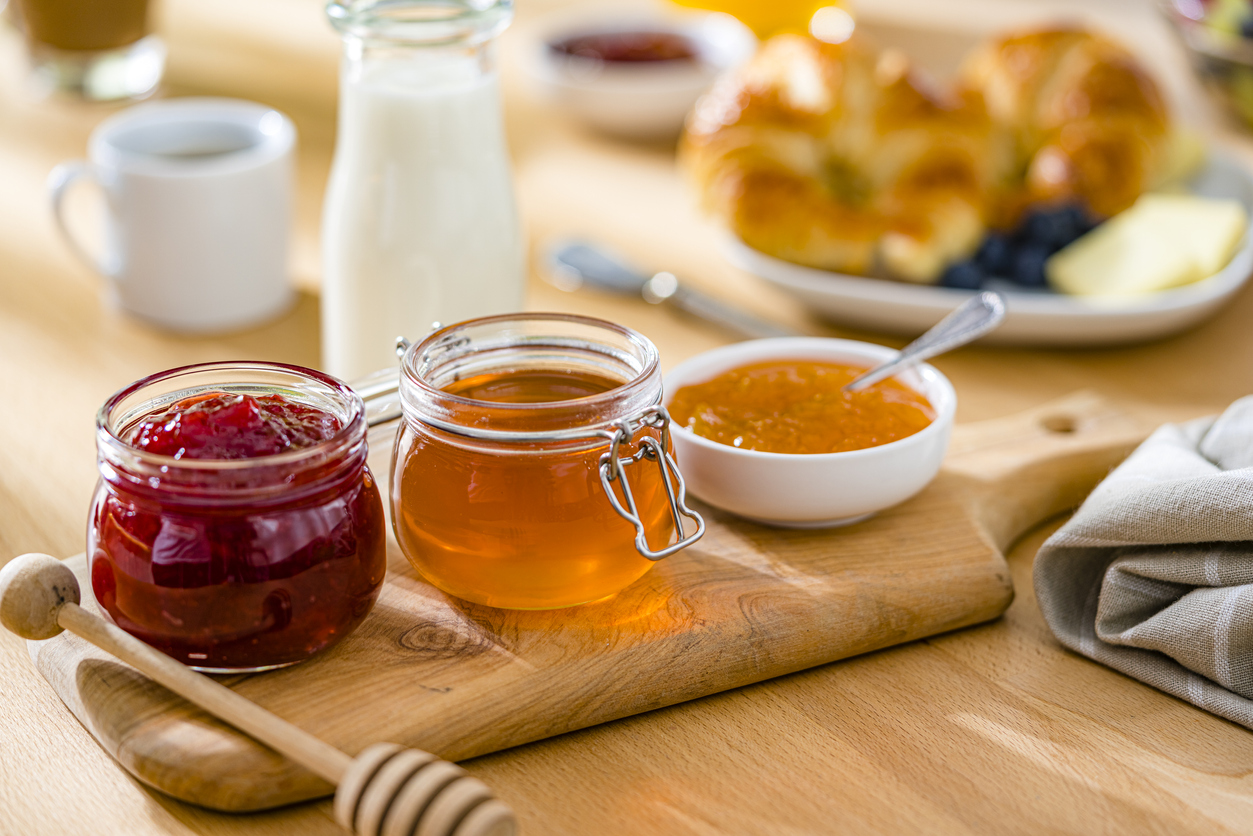Sweet food. Jars of jam and honeyon breakfast table