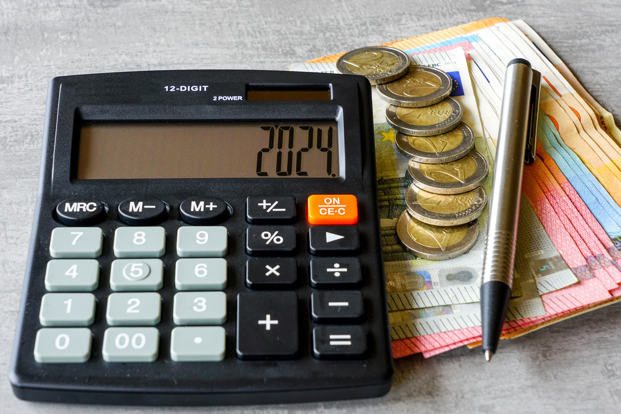 Calculator with number 2024 on display, pen, euro banknotes and euro coins on grey background, calculator with euros 2024