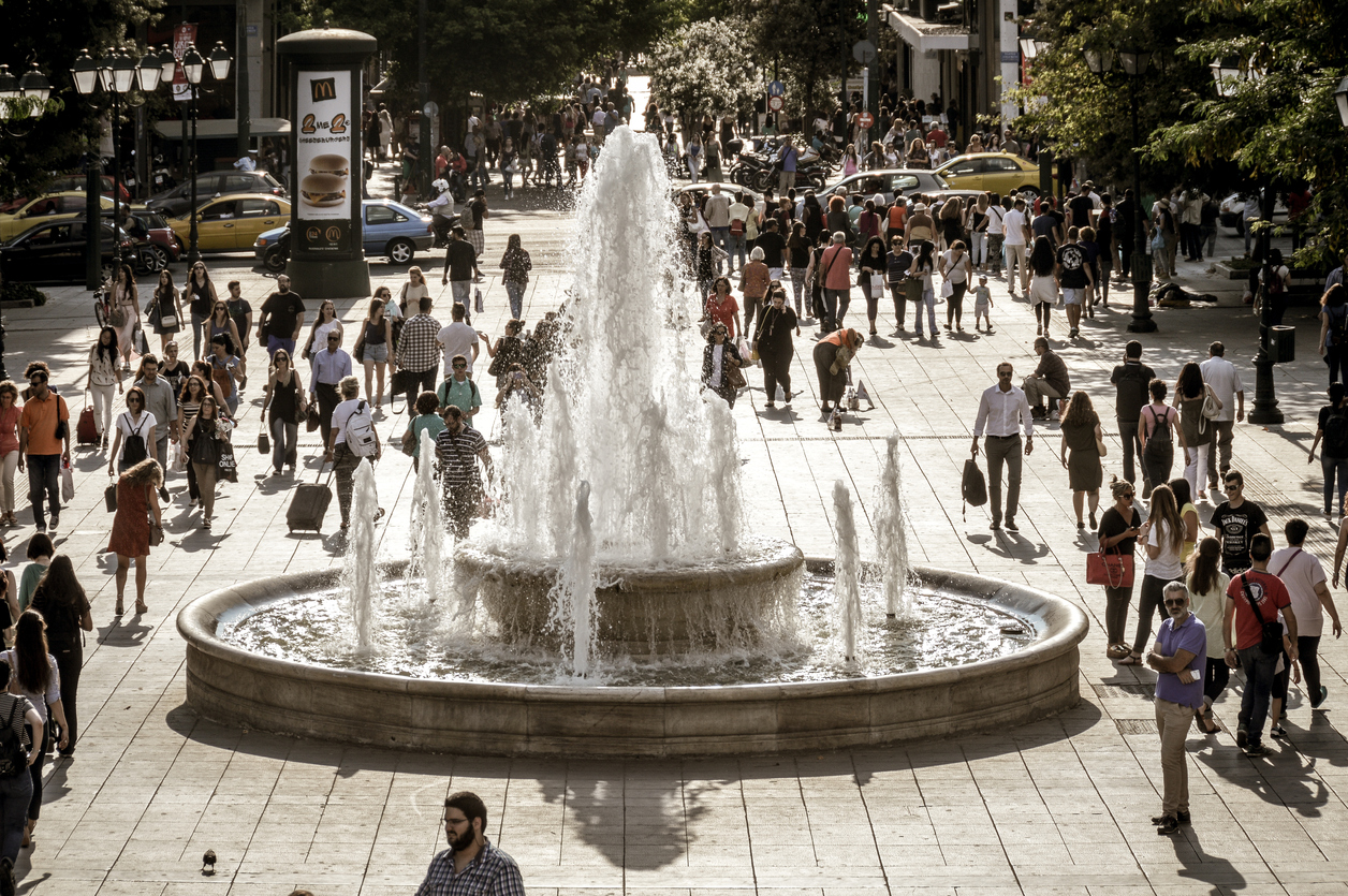 Athens, Greece - June 10, 2016: Syntagma Square, is the central square of Athens. The Square is named after the Constitution that the first King of Greece Otto was obliged to grant, after a popular and military uprising on September 3, 1843. Photo taken during the day and contains locals, tourists, and some vehicular traffic passing through the busy square. The square is dominated by the Old Royal Palace.