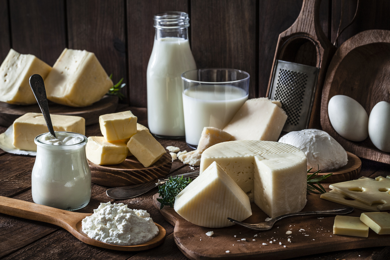 Dairy products assortment shot on rustic wooden table. Dairy products included are milk, yogurt, butter, goat cheese, mozzarella, ricotta, Parmesan cheese, emmental cheese, eggs and hard cheese. Low key DSRL studio photo taken with Canon EOS 5D Mk II and Canon EF 100mm f